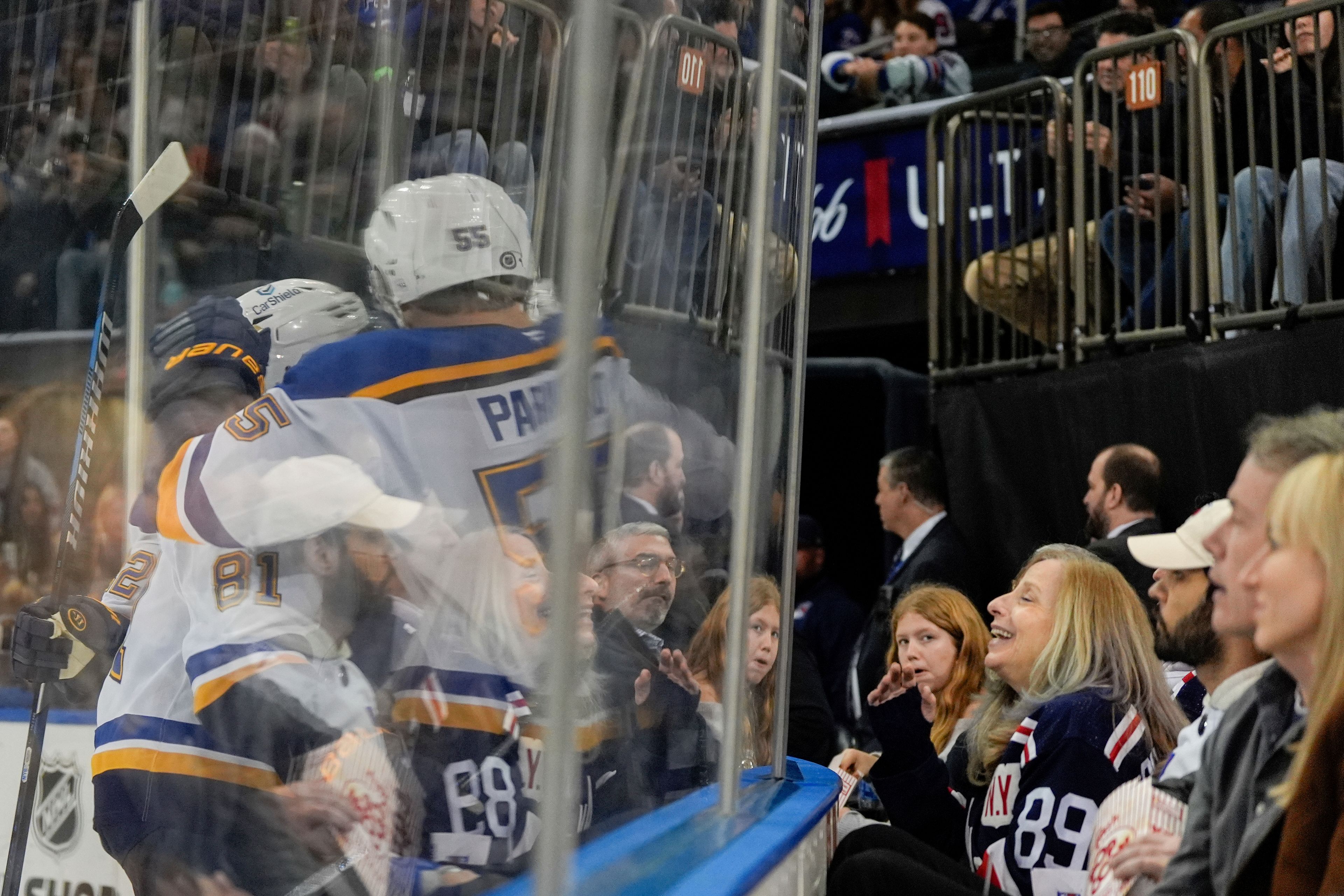 Hockey fans look on as St. Louis Blues defenseman Colton Parayko (55), center Dylan Holloway (81) and others celebrate St. Louis Blues center Zack Bolduc's goal during the second period of an NHL hockey game against the New York Rangers, Monday, Nov. 25, 2024, in New York. (AP Photo/Julia Demaree Nikhinson)