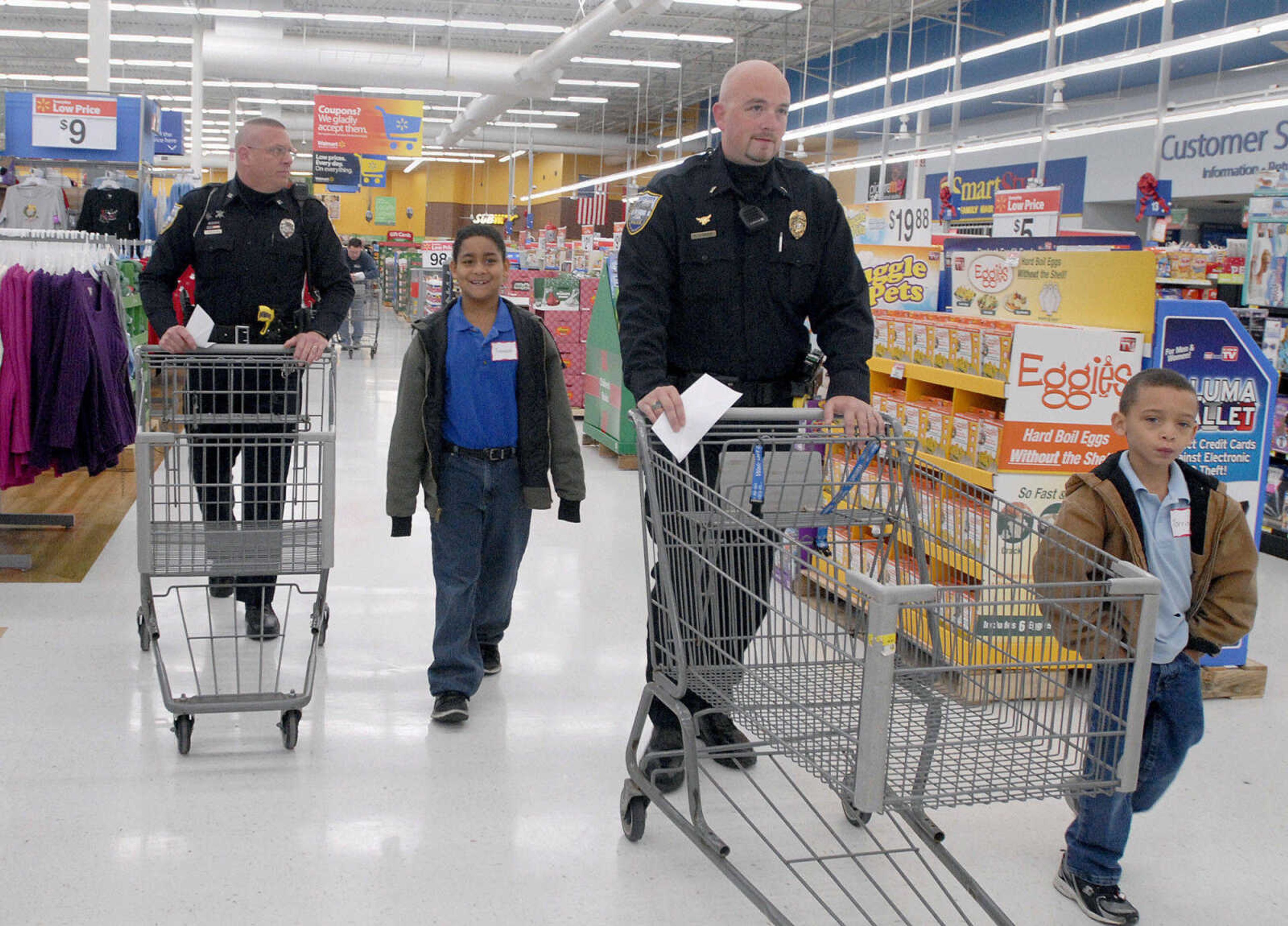 LAURA SIMON ~ lsimon@semissourian.com
Scott City police officers Dan McMichael, left, and Casey Dodd help Trenton Keller, second from left, and Torrin Johnson with their Christmas list Tuesday morning, Dec. 6, 2011 as part of Shop with a Hero at Walmart in Cape Girardeau.