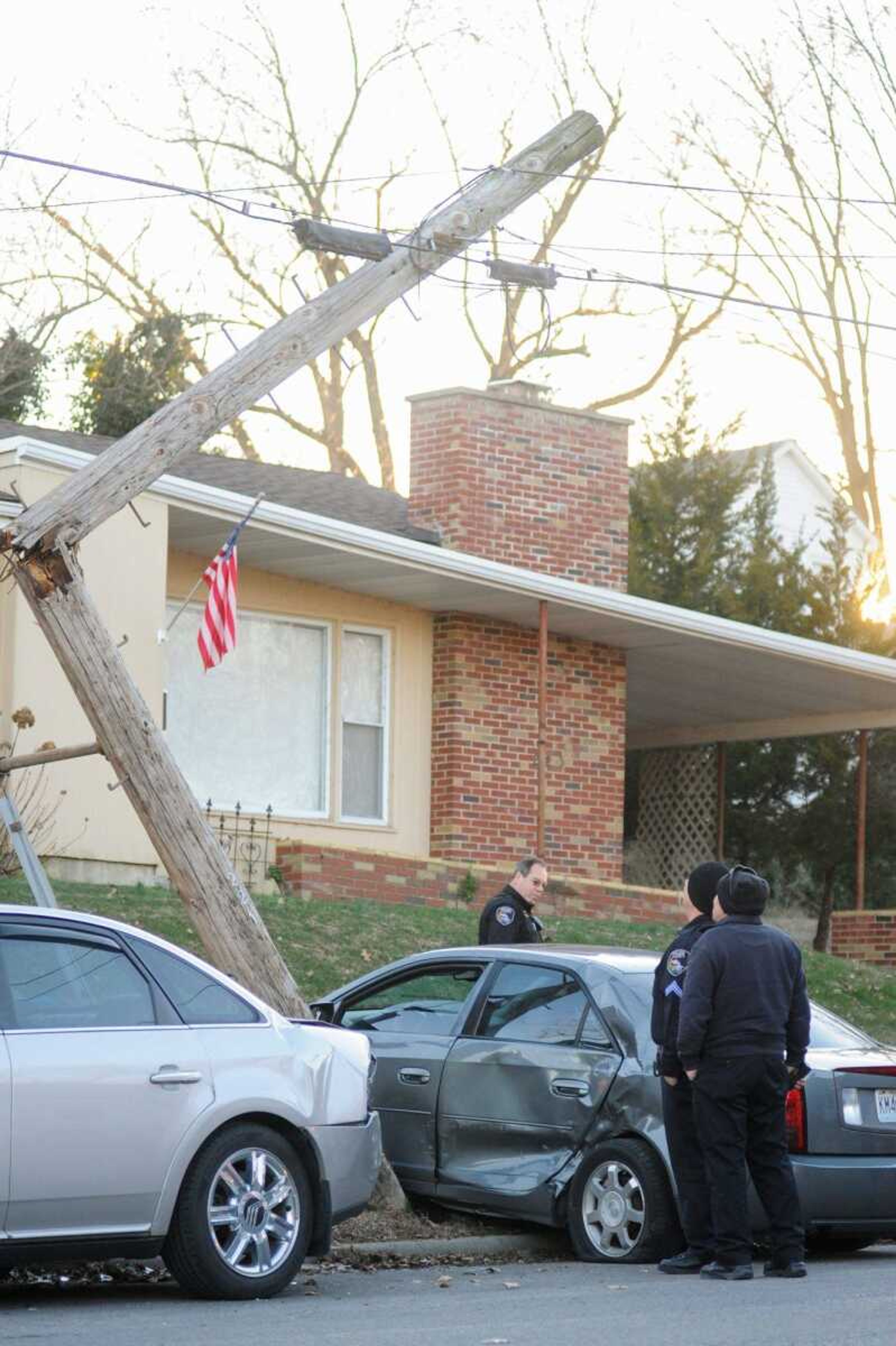 Members of the Cape Girardeau police and fire departments look over the scene of an accident Tuesday that damaged a utility pole at William and Lorimier streets. (Glenn Landberg)