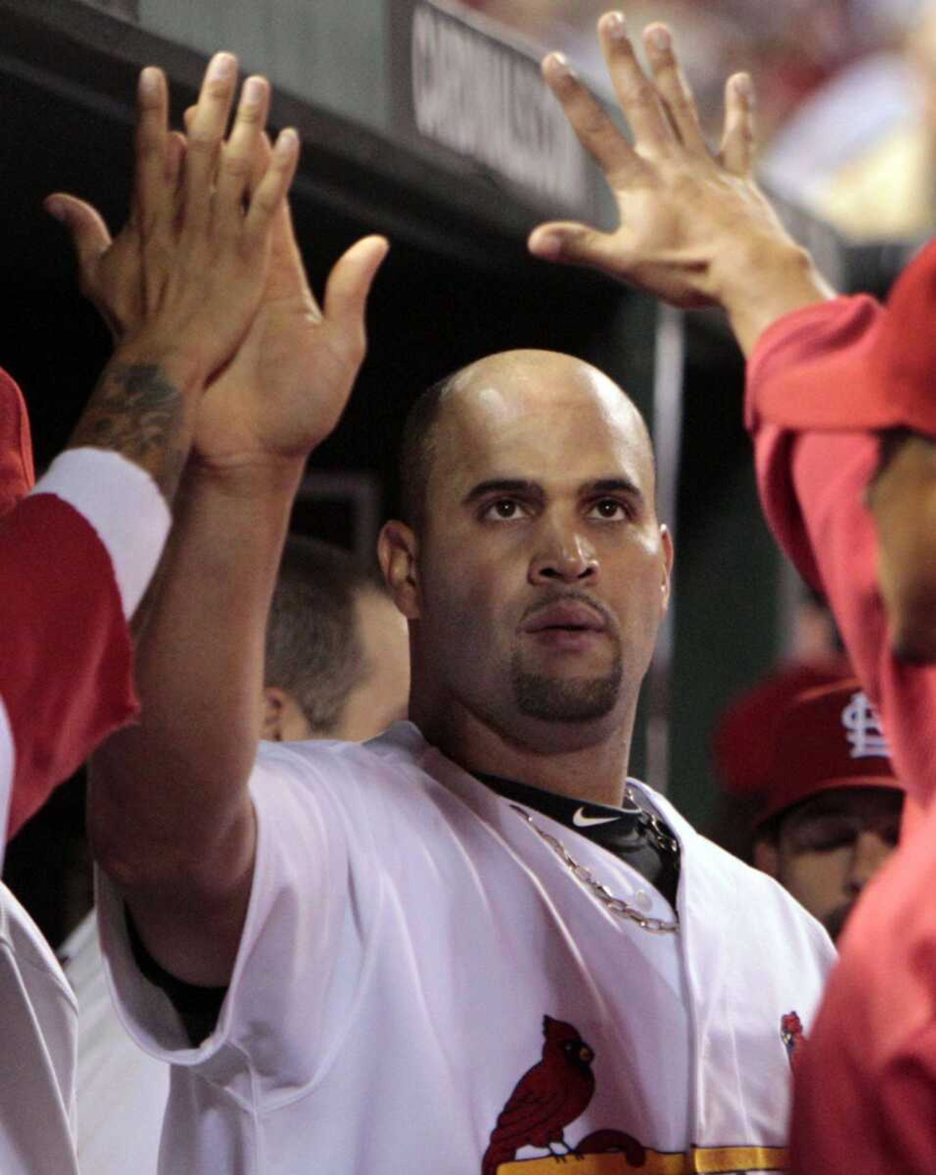 The Cardinals' Albert Pujols is congratulated by teammates in the dugout after he and Jon Jay scored on a single by Yadier Molina during the sixth inning Thursday in St. Louis. (Jeff Roberson ~ Associated Press)