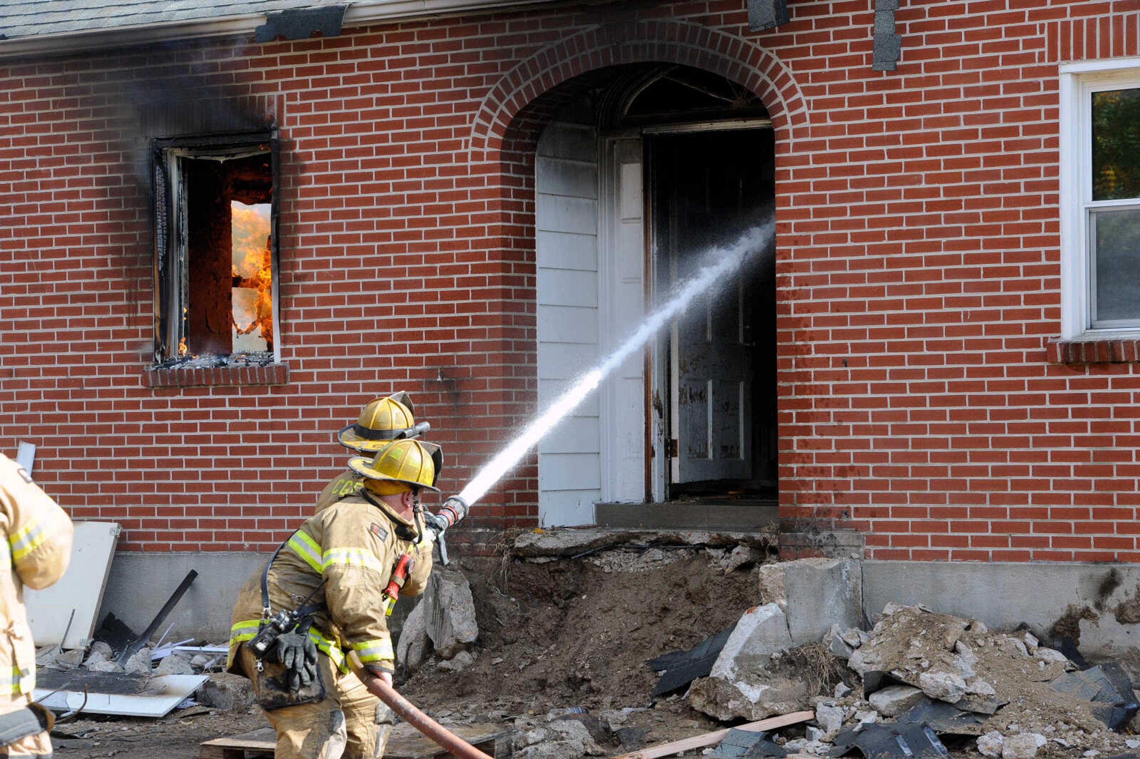 First- and second-year firefighters spray the structure at 222 N. Middle St. with a hose at the live burn exercise held by the Cape Girardeau Fire Department on Friday, Oct. 23, 2020.