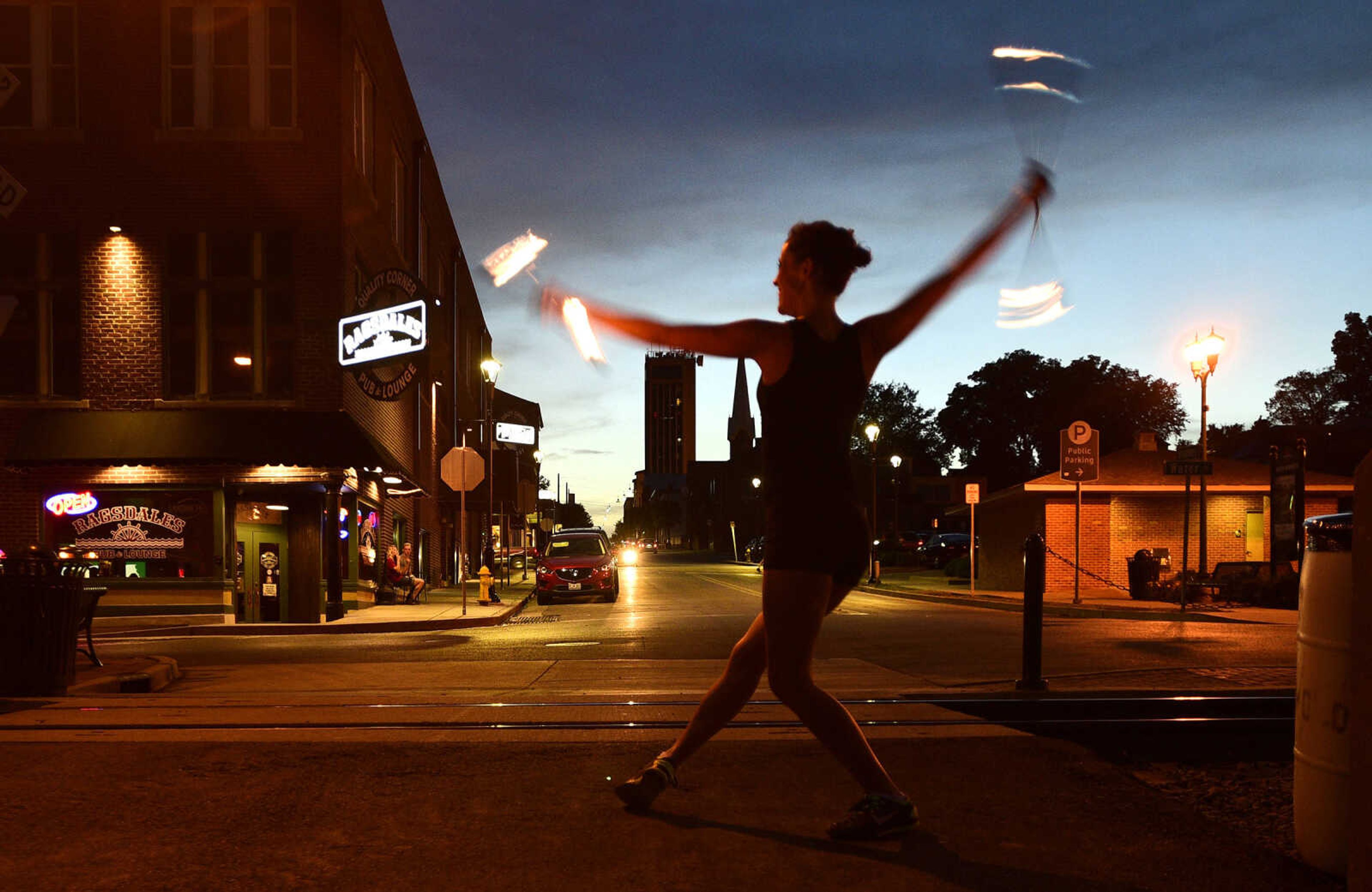 Erin Fluegge twirls flaming batons along the riverfront on Friday, June 16, 2017, in downtown Cape Girardeau.