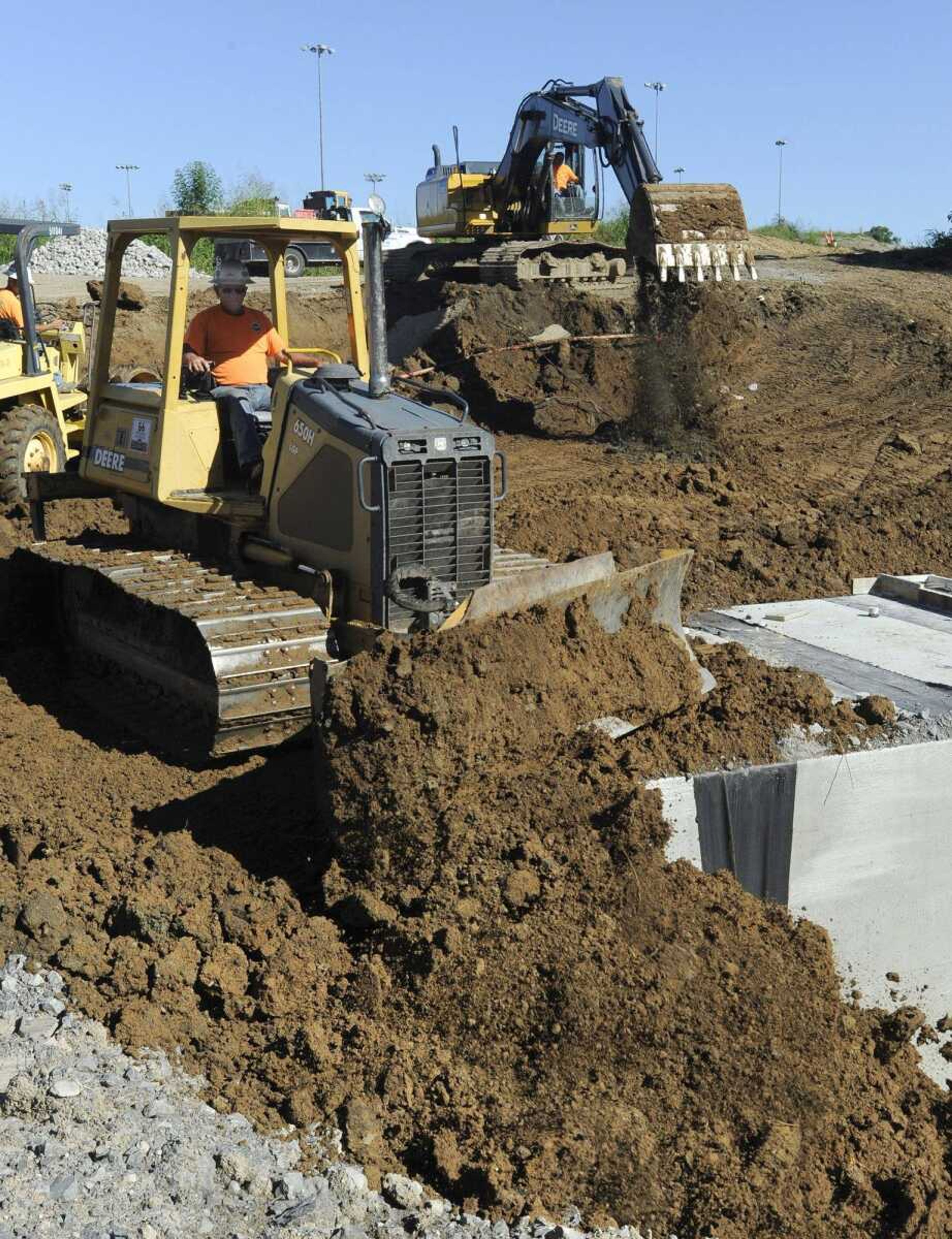 A Fronabarger Concreters crew backfills a box culvert Tuesday along South West End Boulevard east of Shawnee Park as part of a Transportation Trust Fund project in Cape Girardeau. (Fred Lynch)