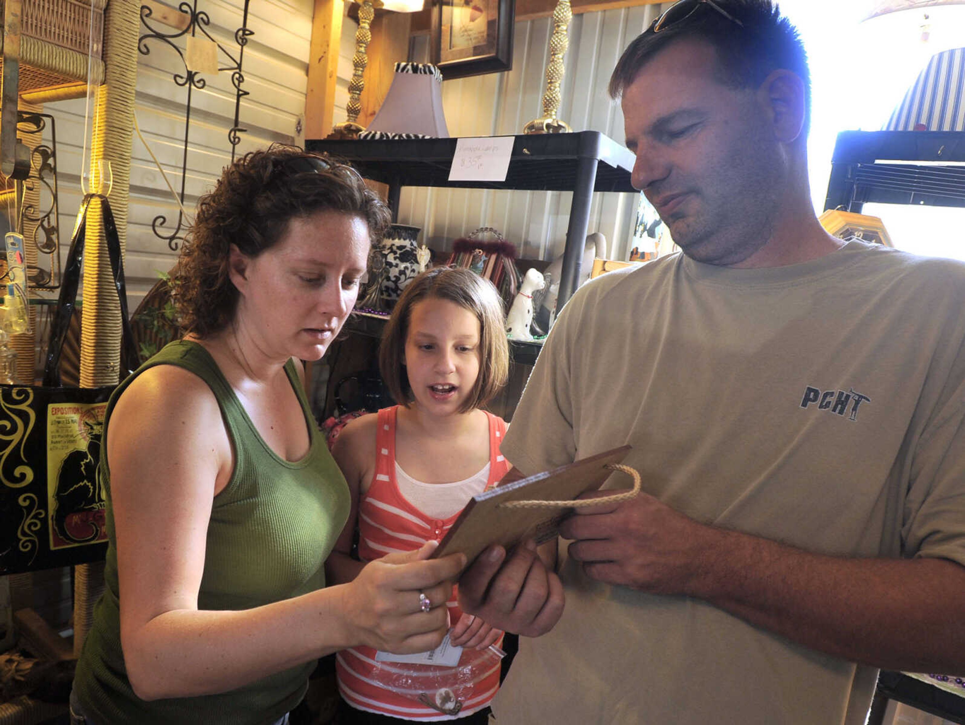 Jessica and Michael Green with their daughter, Mackenzie, of Marble Hill, Mo. browse at Hubble Creek Antiques and More during the Highway 61 Yard Sale Saturday, Aug. 31, 2013 in Jackson.