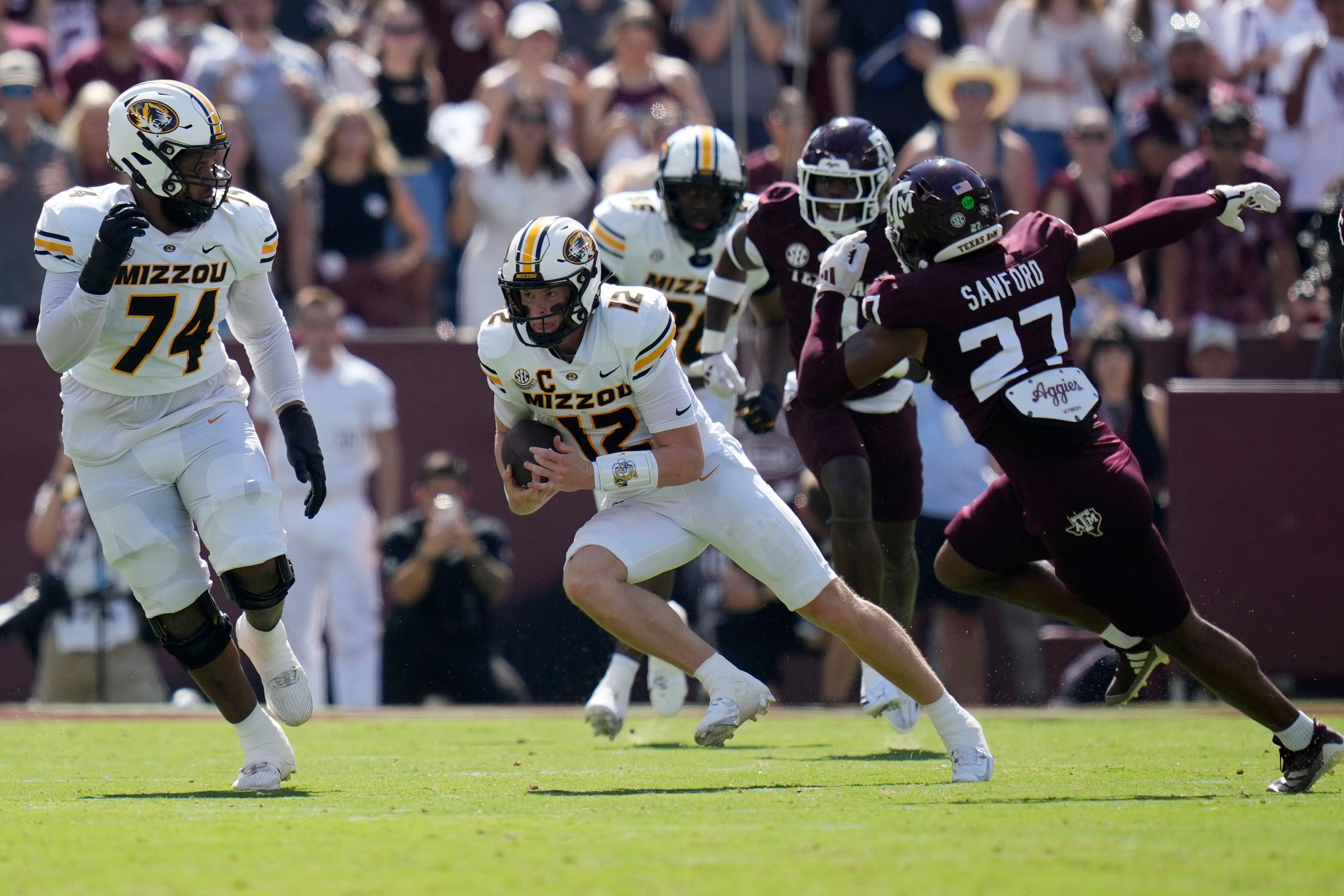 Missouri quarterback Brady Cook (12) tries to escape Texas A&M linebacker Daymion Sanford (27) during the first half of an NCAA college football game Saturday, Oct. 5, 2024, in College Station, Texas. (AP Photo/Eric Gay)