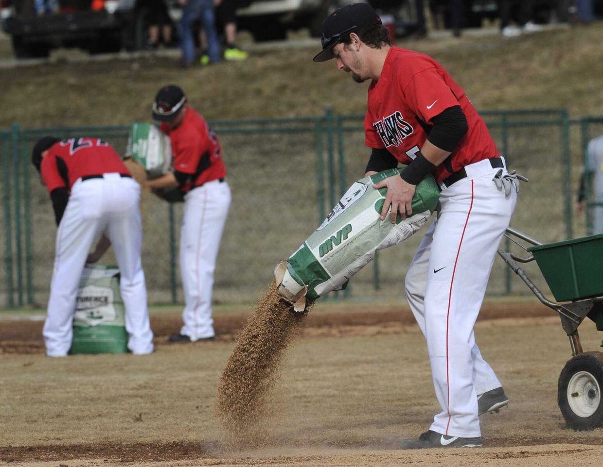 Baseball players treat wet field
