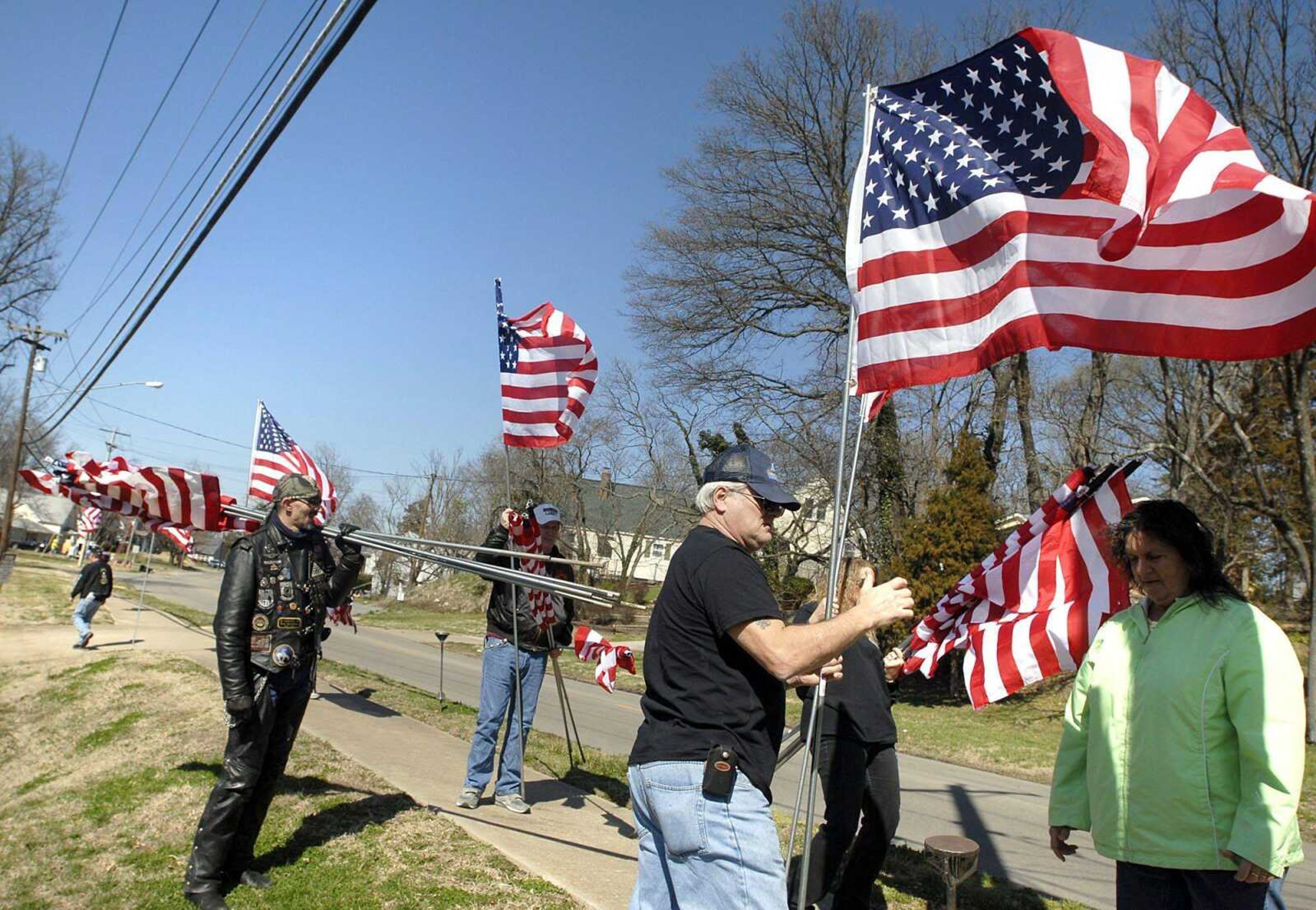 From left, Frank Cruse, Boo Parker, Jim Christensen, Shari Murphy and Linda Long place American flags along West End Blvd. Saturday afternoon, March 3, 2012 in Cape Girardeau. The volunteers were placing flags along West End from Crain Funeral Home to Capaha Park. Around 2,200 flags will be placed along stretches in Cape Girardeau, Olive Branch and Mounds, Ill., in honor of fallen soldier Joshua Born. Born was killed while serving in Afghanistan during fallout from the recent Quran burnings. (Laura Simon)