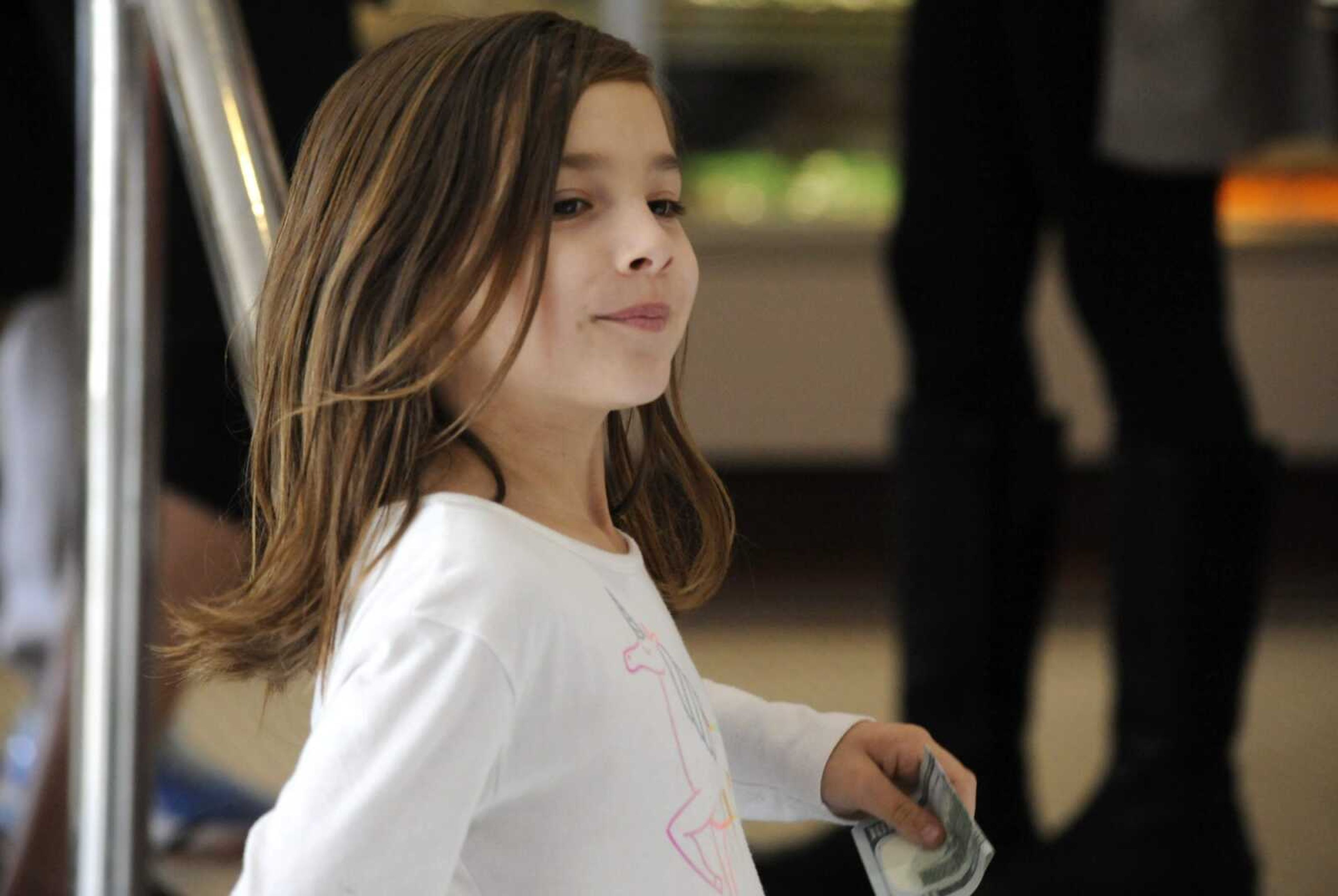 Liza Scott, who is running a lemonade stand to help fund her own brain surgery, holds a donation at her mother's bakery Tuesday in Homewood, Alabama.