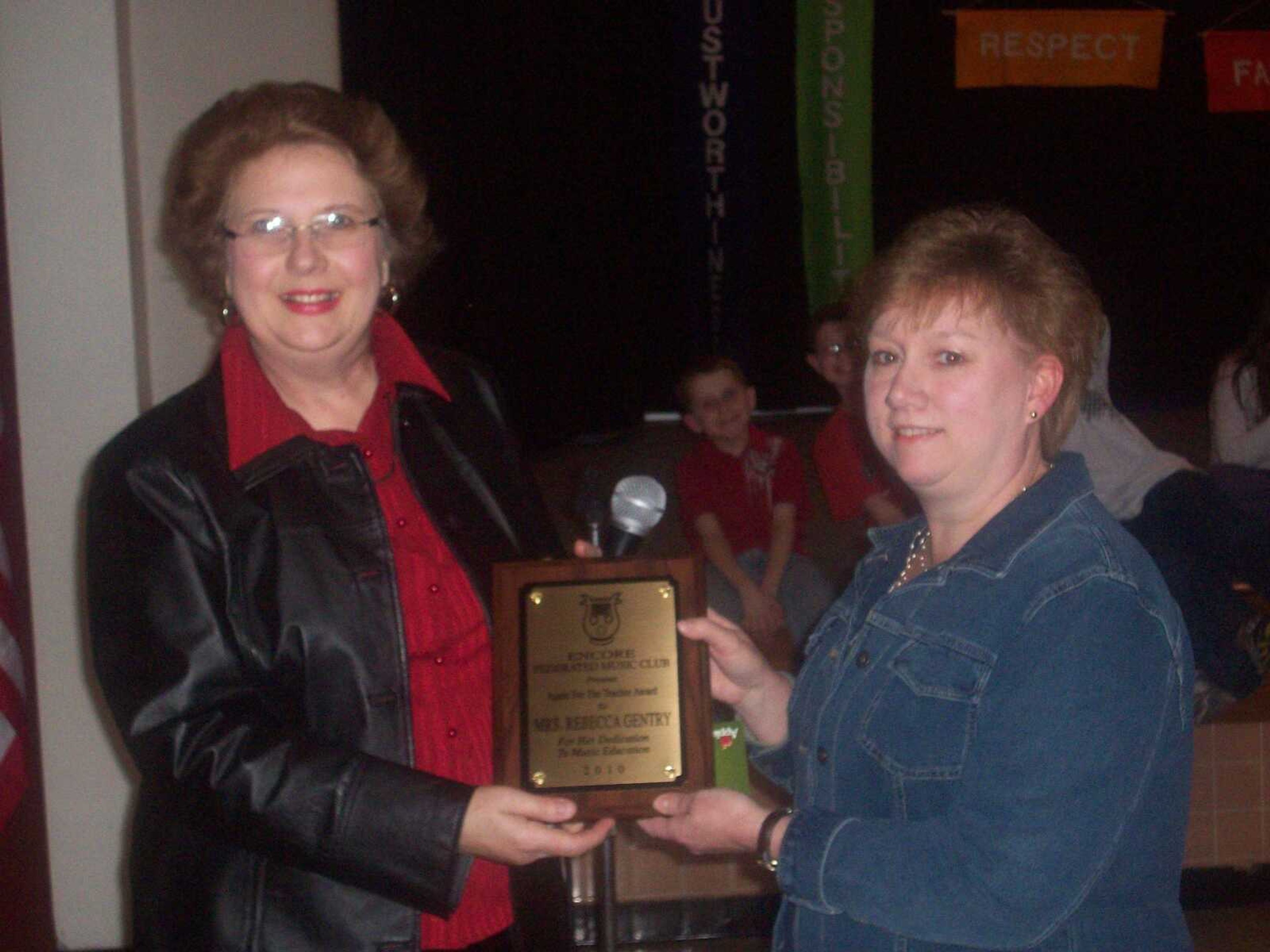 Janet Presson (left) presents the Apple Award and gift certificate to Rebecca Gentry (right).