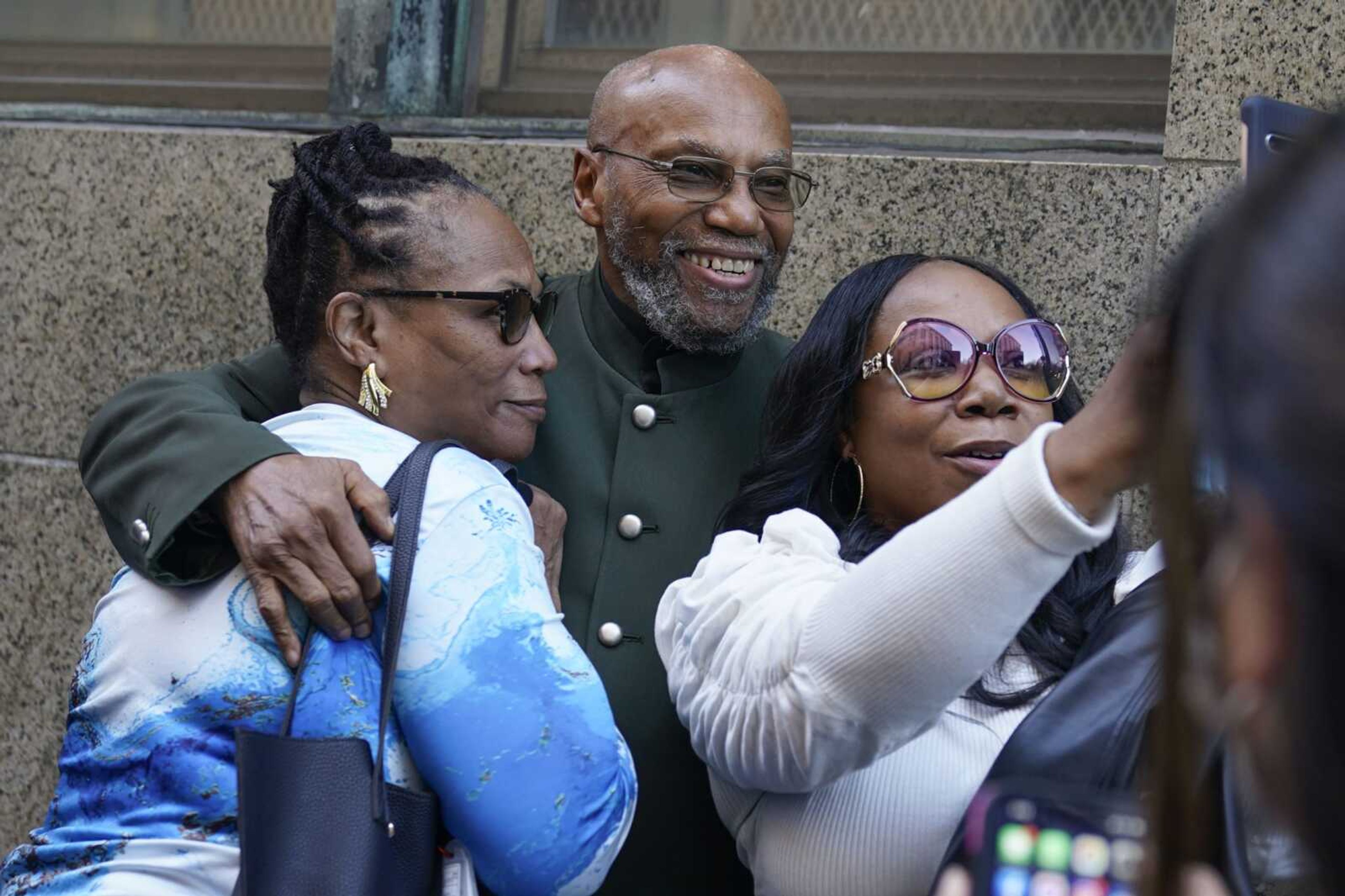 Muhammad Aziz, center, stands outside the courthouse with members of his family after his conviction in the killing of Malcolm X was vacated Thursday in New York.