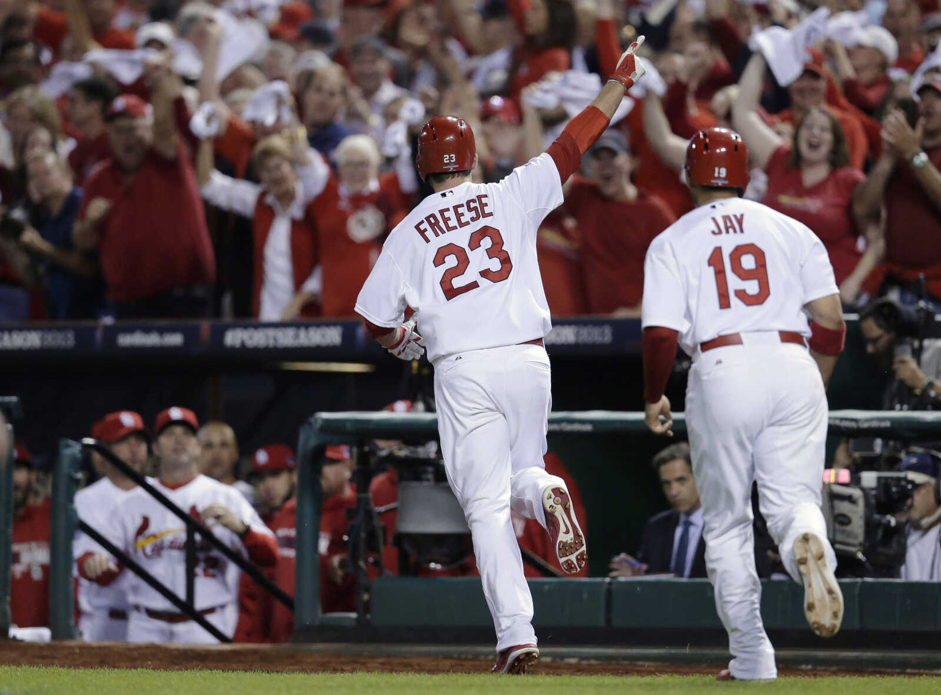 St. Louis Cardinals' David Freese (23) runs to the dugout with Jon Jay (19) after Freese drove in Jay with a two-run home run against the Pittsburgh Pirates in the second inning of Game 5 of a National League baseball division series, Wednesday, Oct. 9, 2013, in St. Louis. (AP Photo/Charlie Riedel)