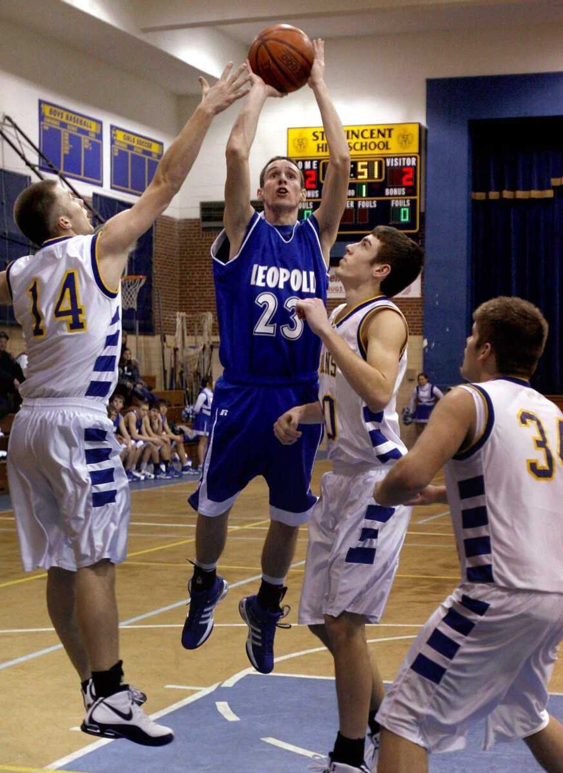 ELIZABETH DODD ~ edodd@semissourian.comLeopold's Darren VanGennip shoots as St. Vincent's Kyle Rollet, left, and Aaron Dzik defend Thursday at St. Vincent.