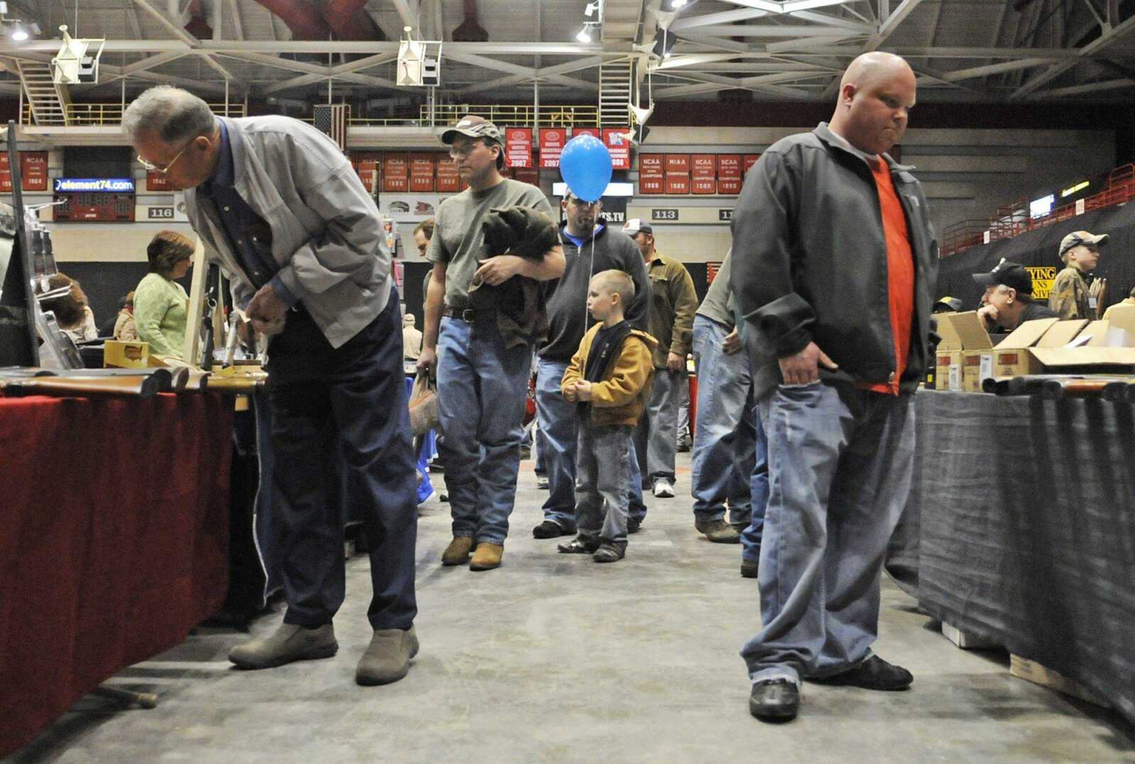 Ethan Weber, 6, holds a balloon as he walks with his father Daniel Weber, center, of Perryville, Mo., during the Missouri Gun and Knife Show at the Show Me Center on Saturday, March 13, 2010. (KRISTIN EBERTS)