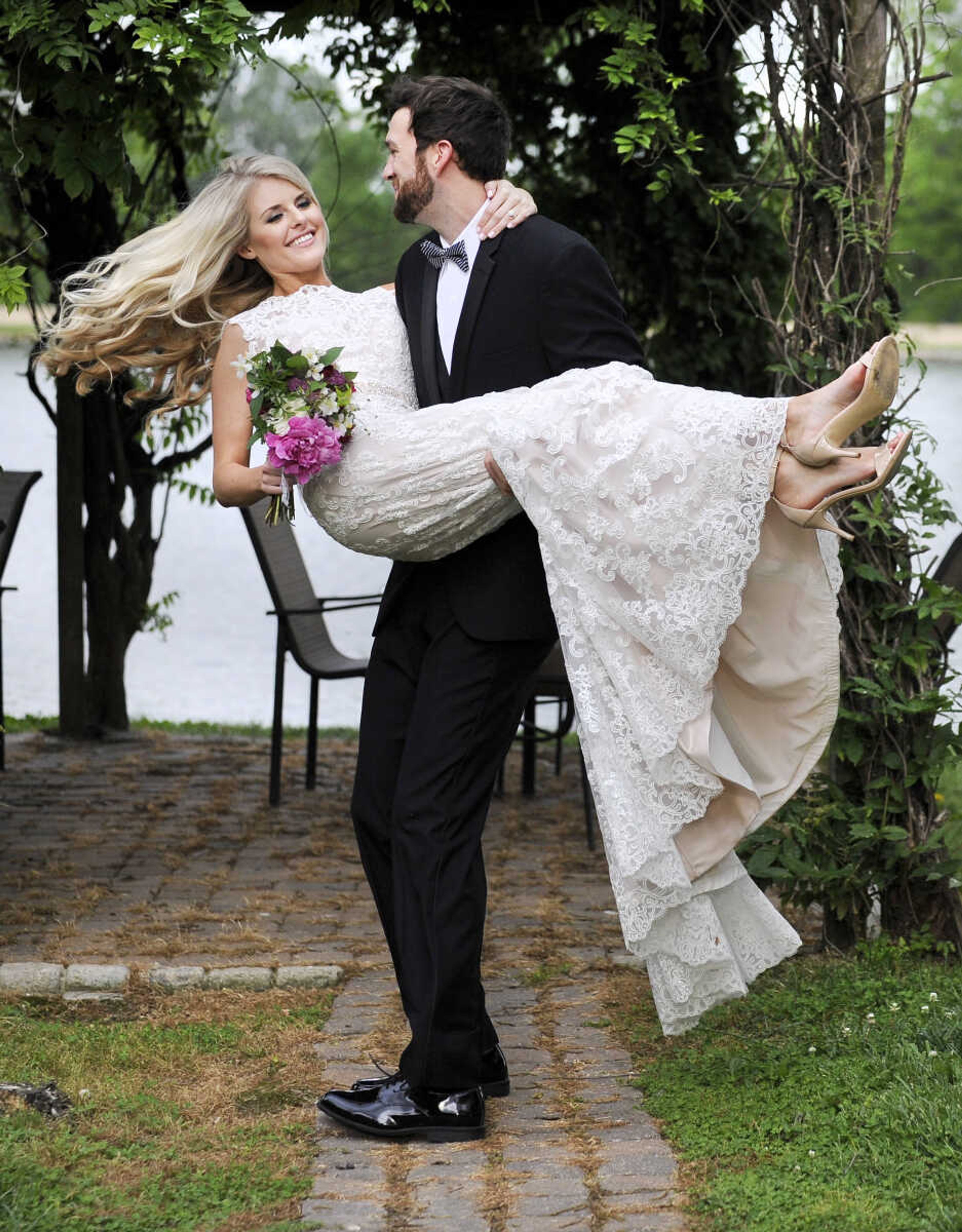 On Paige: This ivory/blush David Tutera "Rumer" gown comes in two pieces, with a Schiffli lace cage dress over a satin A-line dress. The gown also features a tulle skirt, and illusion and scalloped lace bateau neckline and a beaded sweetheart bodice and waisteband. The back has a deep V with crystal button closures and a chapel-length train. The dress is accessorized with a Bel Aire Bridals fingertip-length veil edged with pearls, bugle beads and rhinestones. All available at The Andrew Jackson in Cape Girardeau.

On Spencer: Manhattan slim fit tuxedo with solid black vest and black and white striped bow tie. Provided by Kim's Formal Wear and available at Garber's Men's Wear in Cape Girardeau.