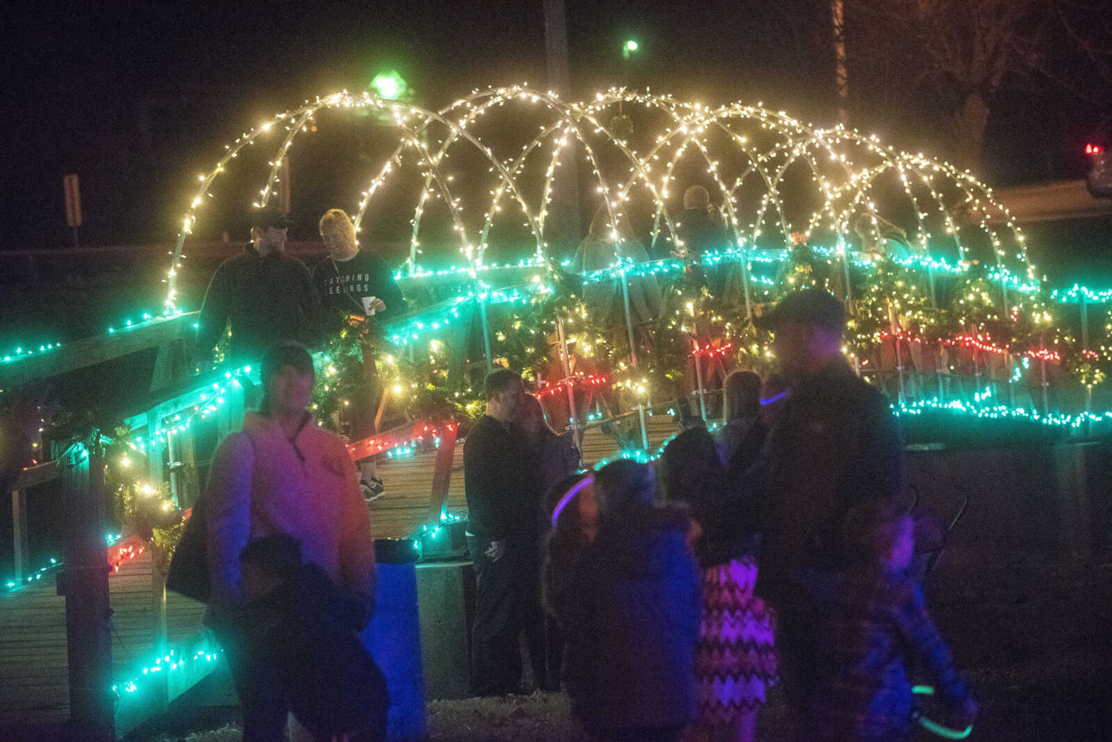 People walk the footbridge during the Jackson Holiday Extravaganza Friday, Nov. 24, 2017 at the Jackson City Park.