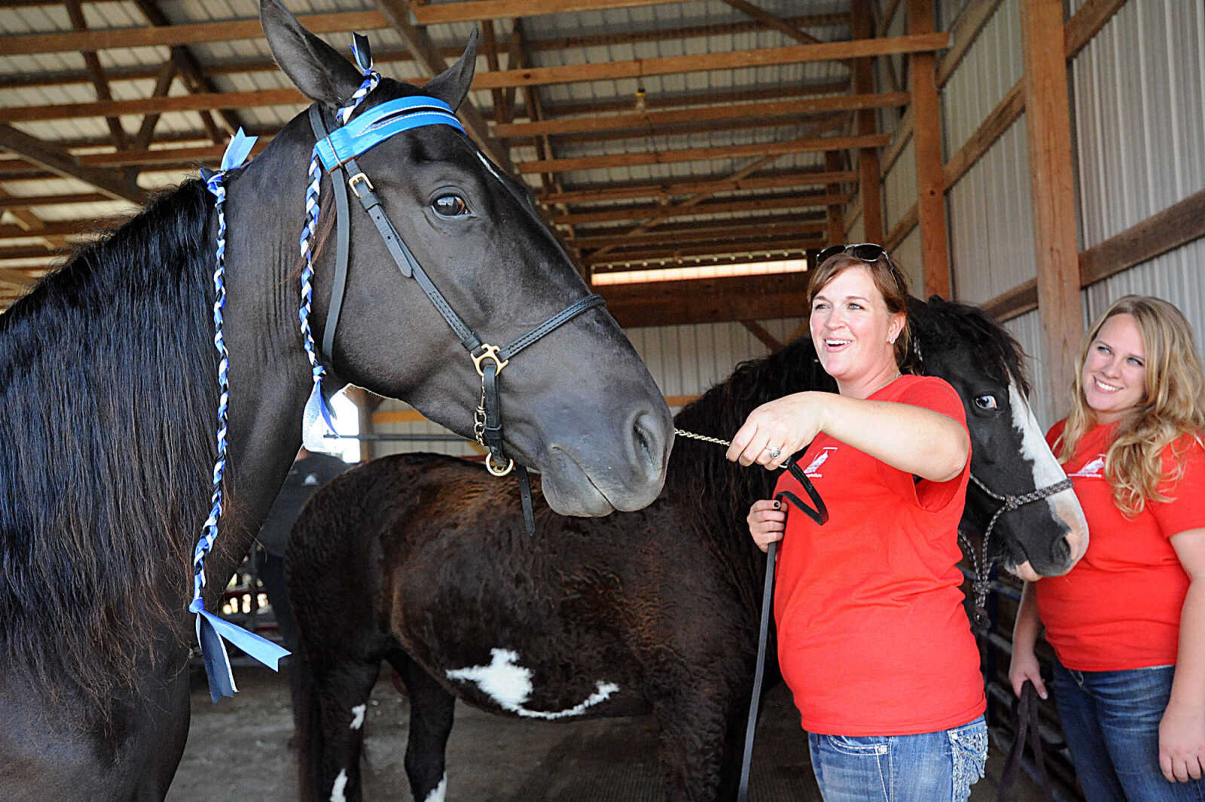 LAURA SIMON ~ lsimon@semissourian.com

Genny Bradshaw, right, holds onto Dutchess, and American curly horse, as Suzanne Summers Grant gets Carson Daly, a Tennessee walking horse, pretty, during the 12th annual Agriculture Education Field Day hosted by Southeast missouri State University's Department of Agriculture. Around 400 students from area schools spent the day learning at the Charles Hutson Horticulture Greenhouse and the David M. Barton Research Center.