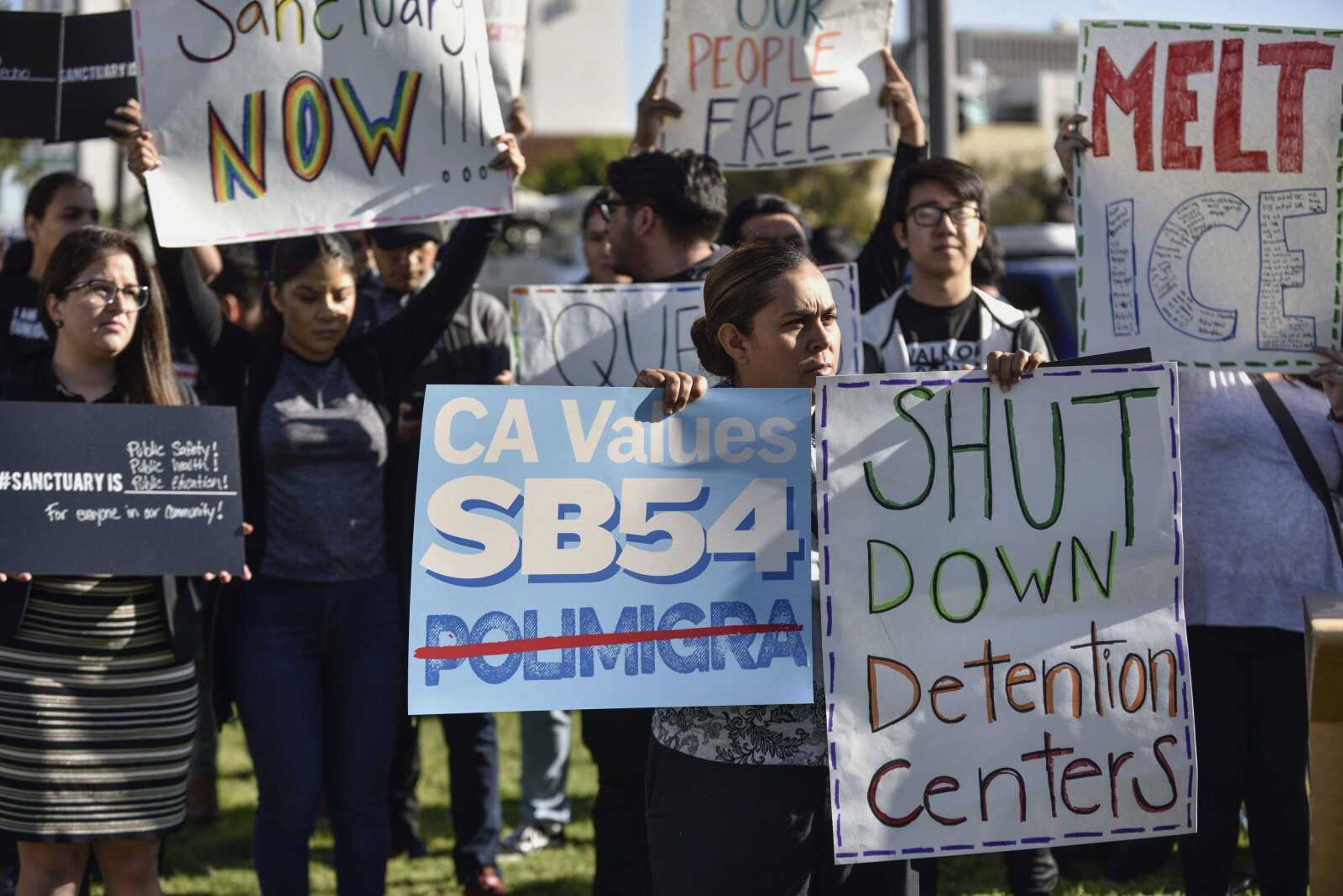 A small group of sanctuary state supporters gather Tuesday outside the Orange County Board of Supervisors meeting in Santa Ana, California, as the officials prepare to discuss joining a lawsuit against the state of California over so-called "sanctuary" immigration policies.