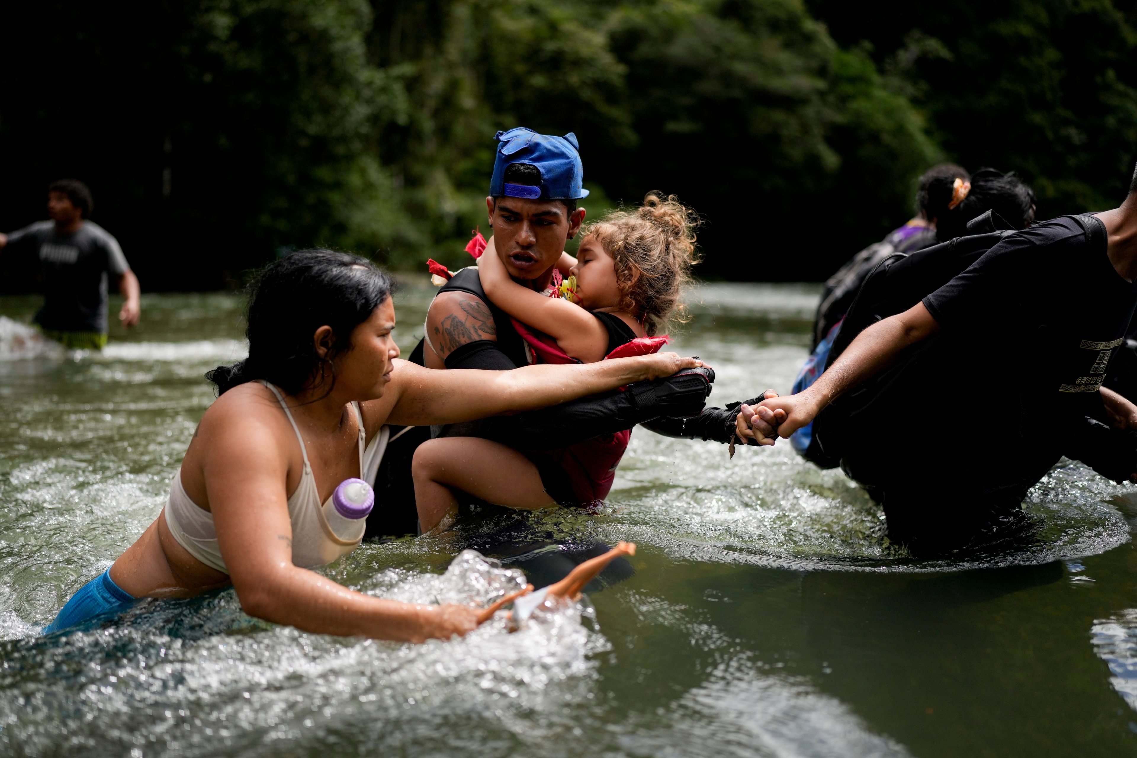 Venezuelan migrant Alvaro Calderini carries his niece across a river near Bajo Chiquito, Panama, after walking across the Darien Gap from Colombia on their way north to the United States, Saturday, Nov. 9, 2024. (AP Photo/Matias Delacroix)