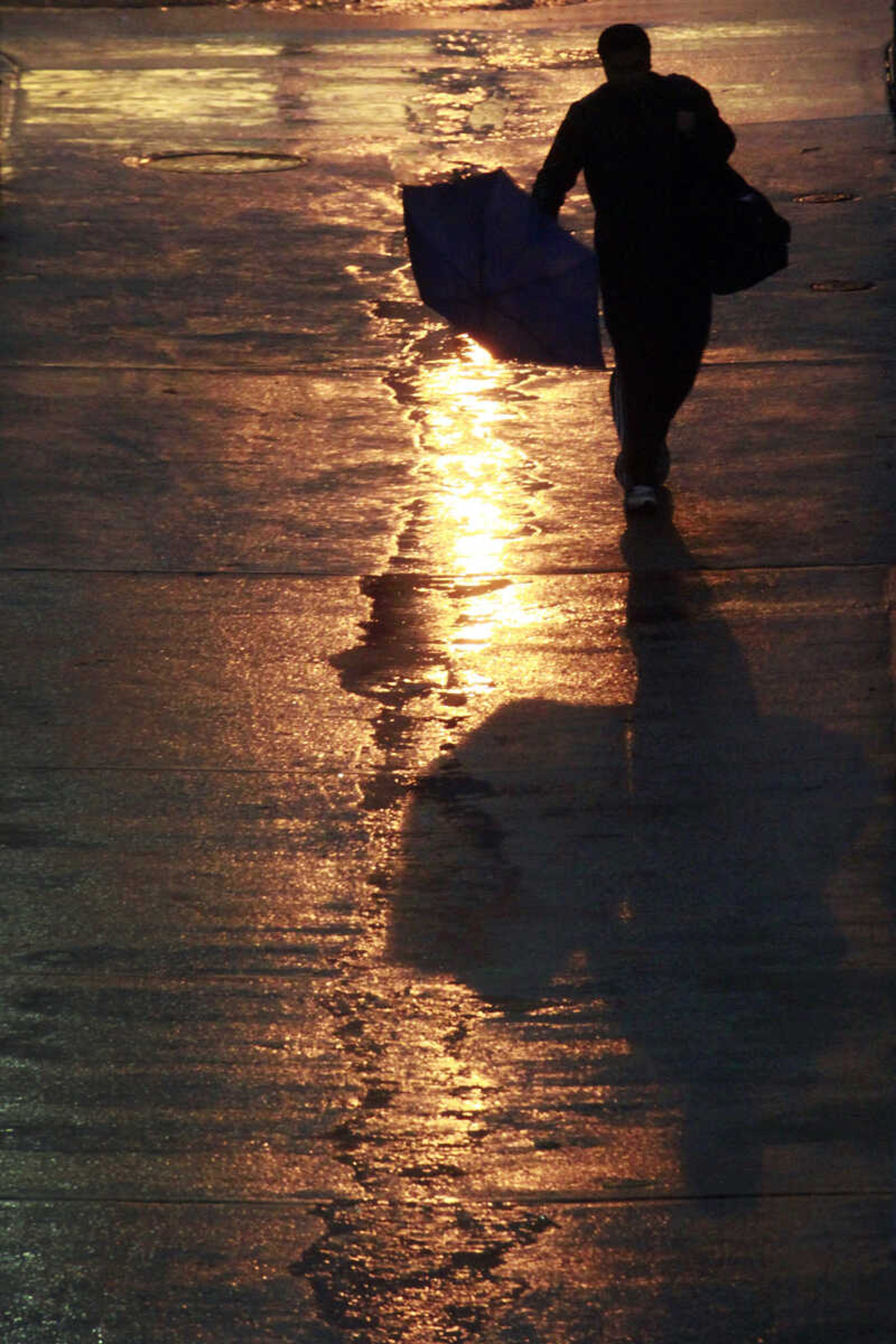 A pedestrian walks through light rain early Monday morning, Oct. 29, 2012, in Washington as Hurricane Sandy approaches the east coast. The wind and rain in the Nation's Capitol is expected to increase though out the day. (AP Photo/J. David Ake)