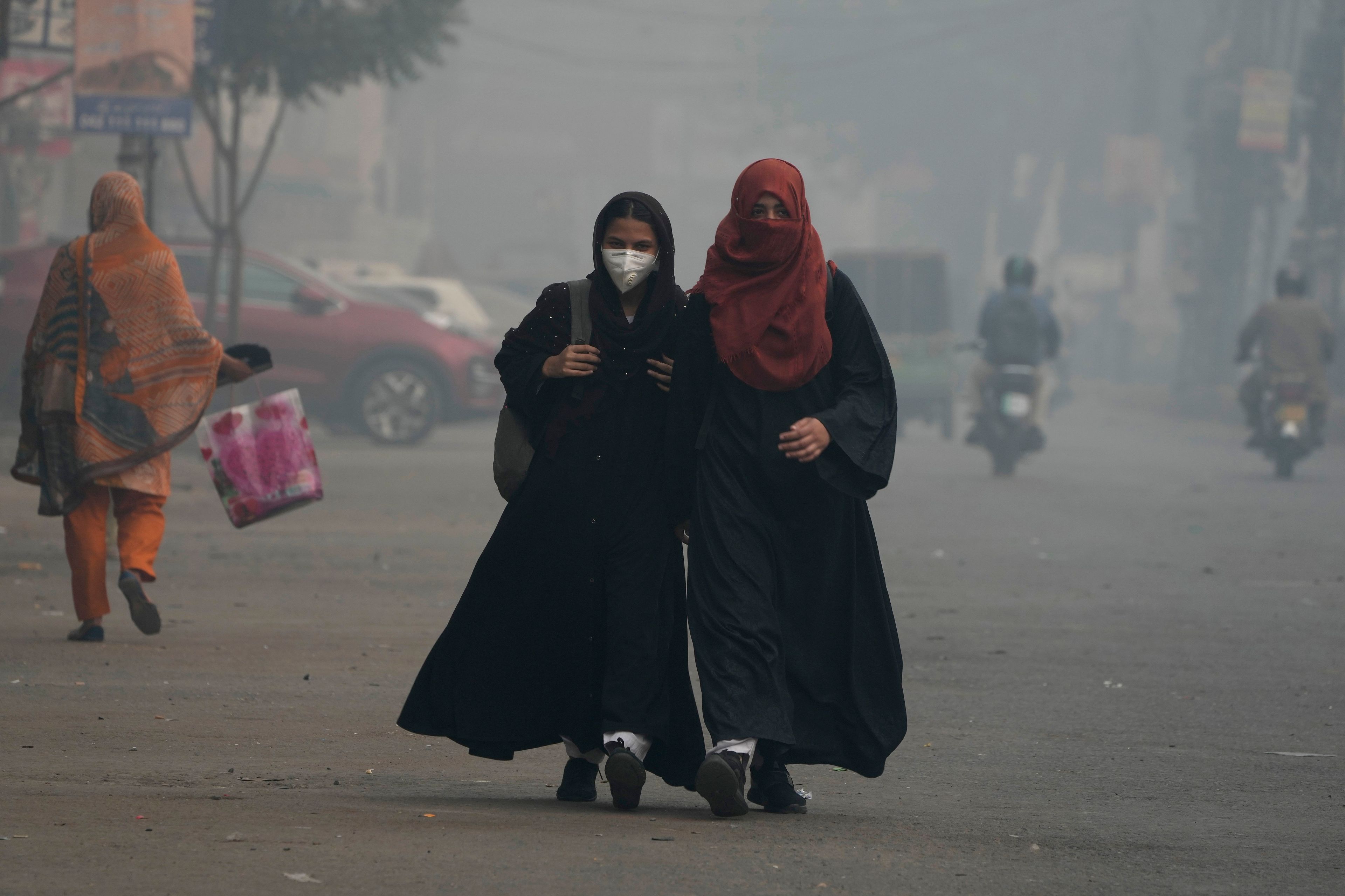 Students wear mask and heading to their school as smog envelops the areas of Lahore, Pakistan, Wednesday, Nov. 6, 2024. (AP Photo/K.M. Chaudary)