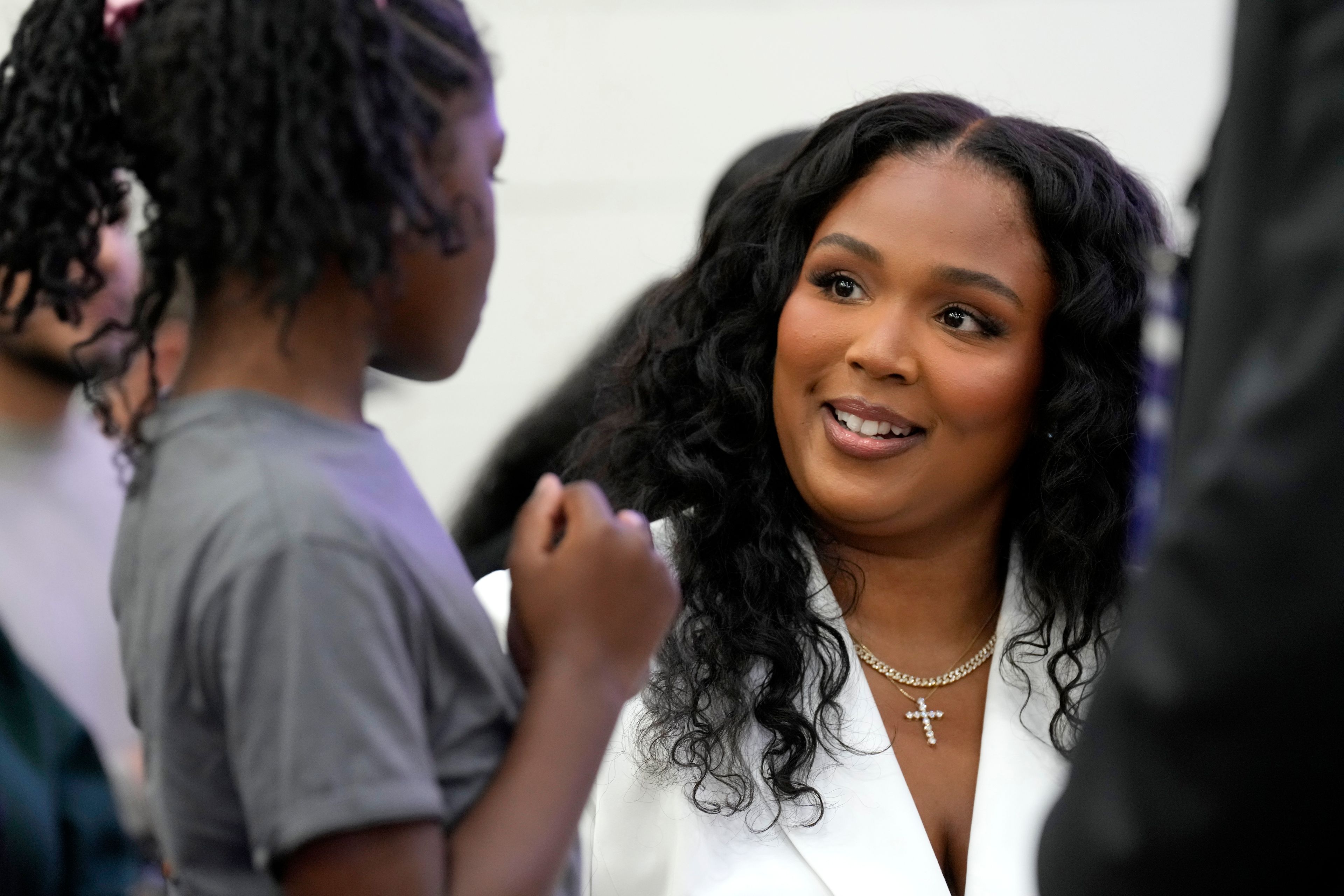 Lizzo, right, sits with a young attendee before Democratic presidential nominee Vice President Kamala Harris speaks during a campaign event at Western International High School in Detroit, Saturday, Oct. 19, 2024. (AP Photo/Jacquelyn Martin)