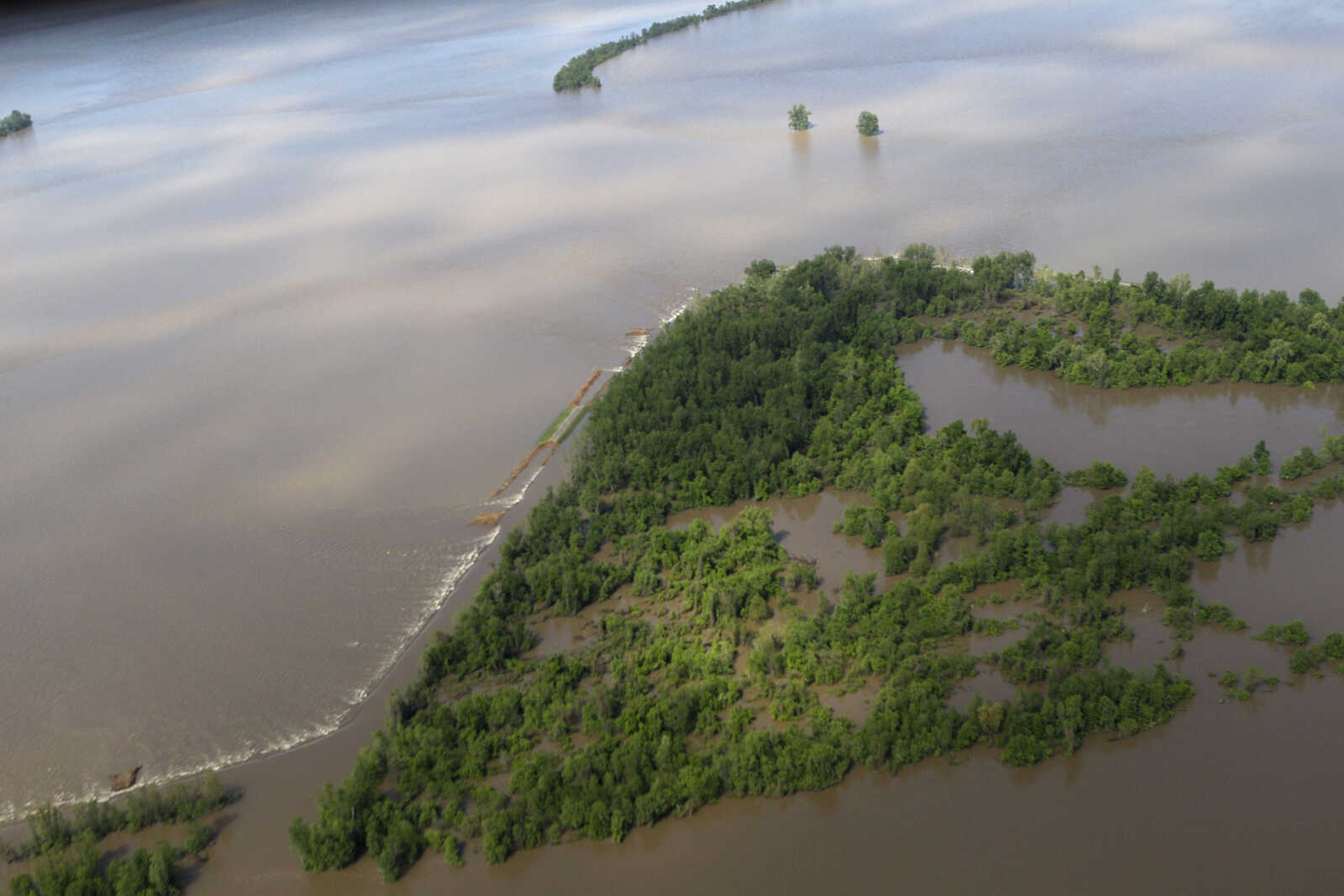 Water creates a white cap as it flows over where the Birds Point levee once stood Tuesday, May 3, 2011, in Mississippi County, Mo.  The Army Corps of Engineers blew a two-mile hole Monday night into the levee in southeast Missouri, flooding 130,000 acres of farmland in Missouri's Mississippi County in an effort to protect nearby Cairo, Ill. from rising floodwaters. (AP Photo/Jeff Roberson)