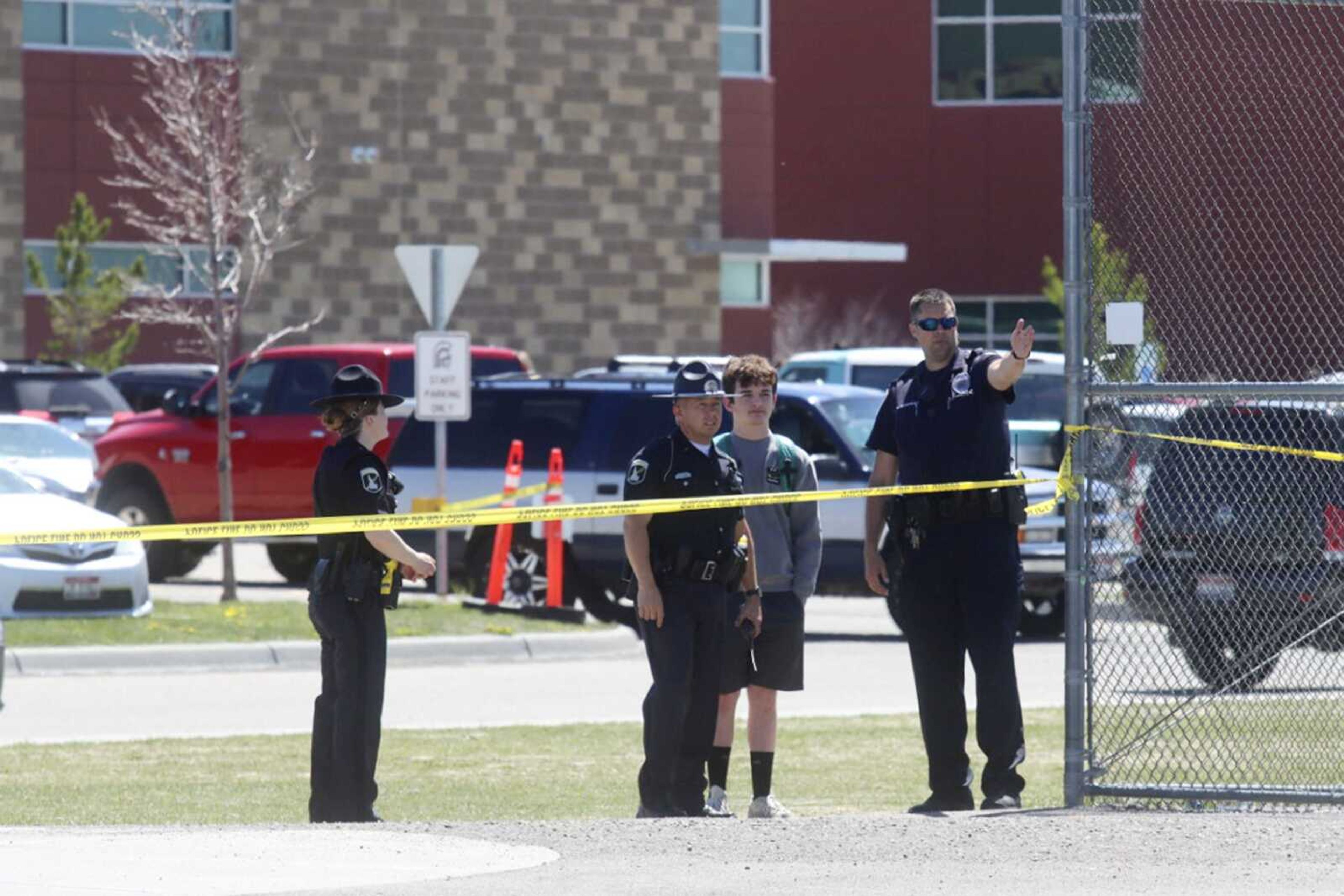 Police stand with a youth outside Rigby Middle School following a shooting there earlier Thursday in Rigby, Idaho.