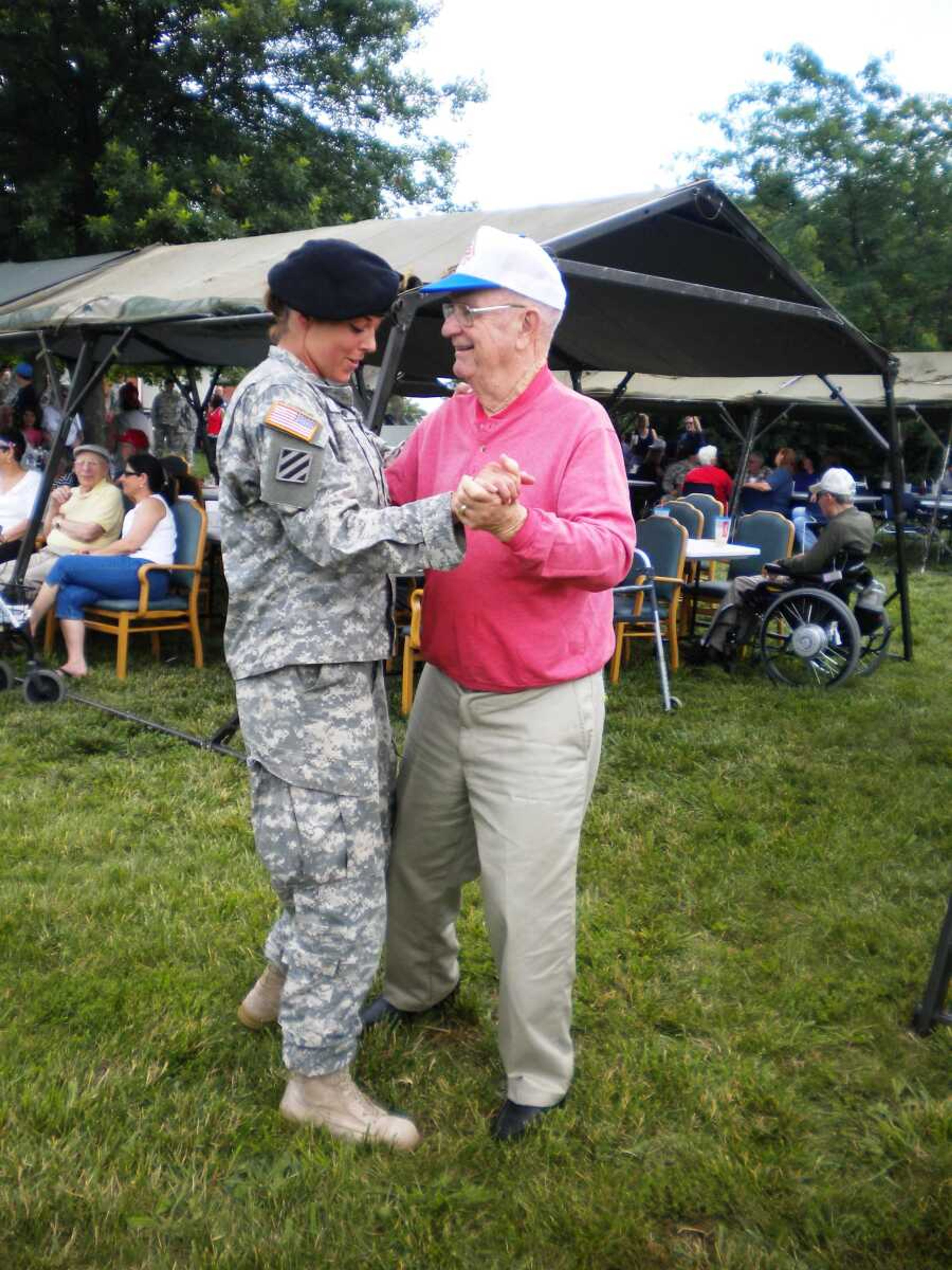 Sgt. Amy Shremp dances with a Veterans Home resident Saturday at a picnic in which veterans were paired with younger Soldiers. (Photo by Sgt. Heather Weimer)