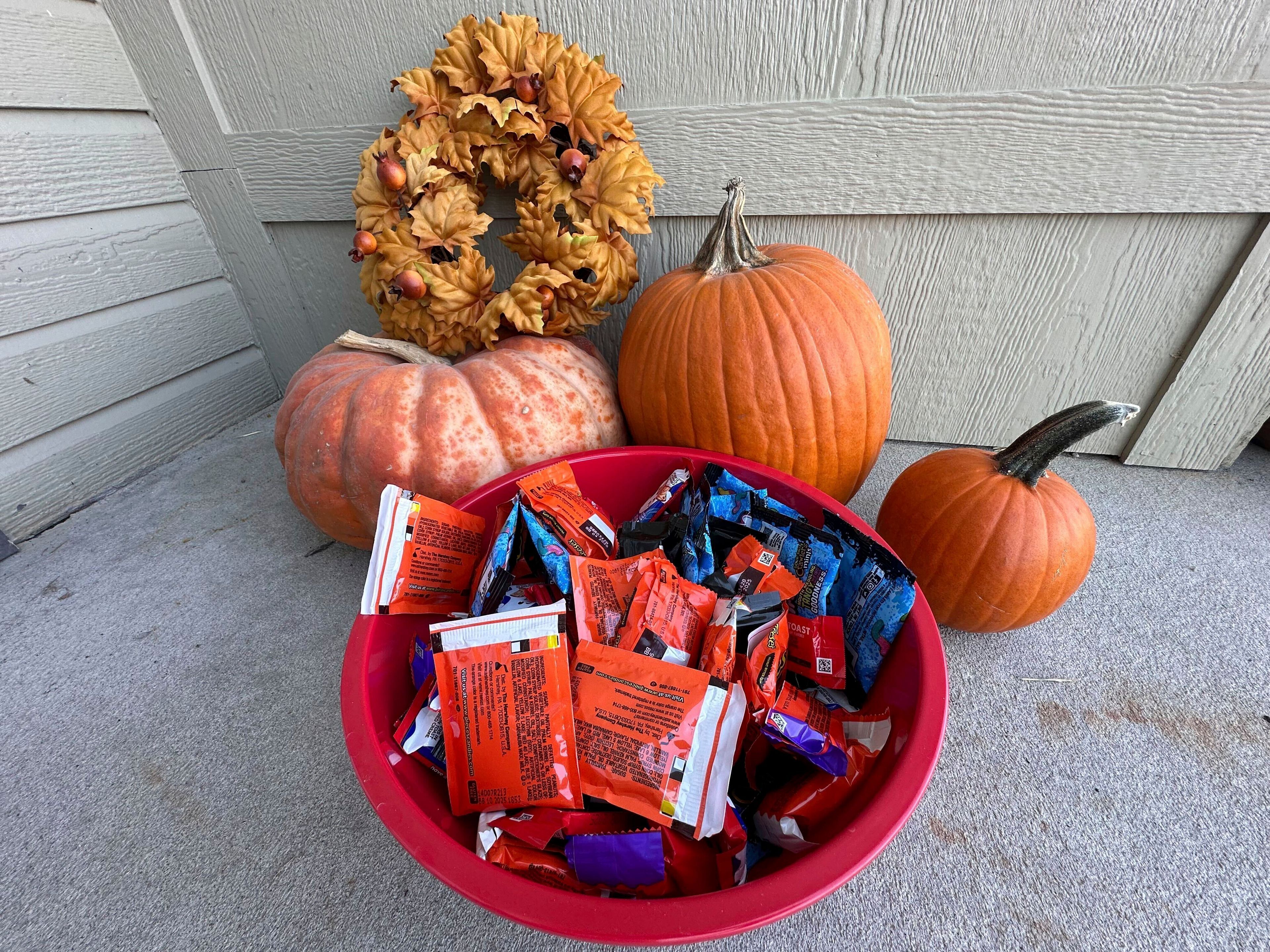 Halloween candy and pumpkins sit outside of a home Friday, Oct. 11, 2024, in St. Joseph, Mo. (AP Photo/Nick Ingram)