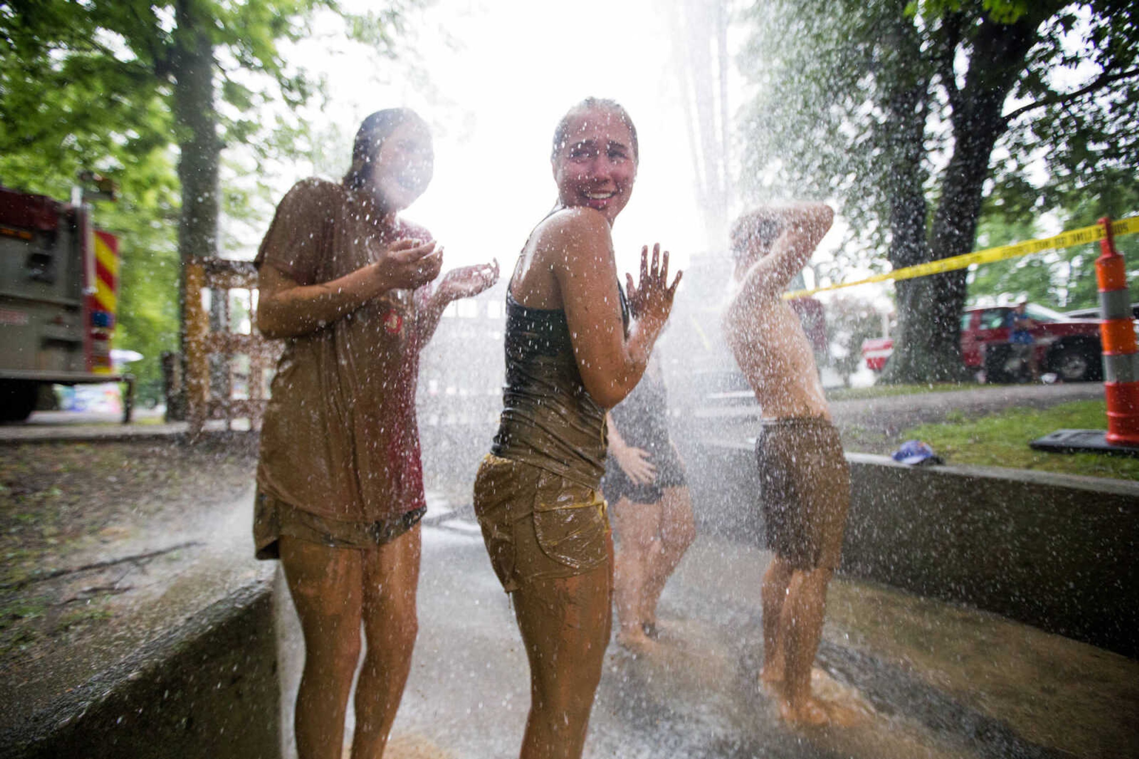 GLENN LANDBERG ~ glandberg@semissourian.com

Hillary Eckley and Autumn Gragg rinse off under the spray of a firetruck after a game in the mud volleyball tournament during the Fourth of July celebration Monday, July 4, 2016 at Jackson City Park.