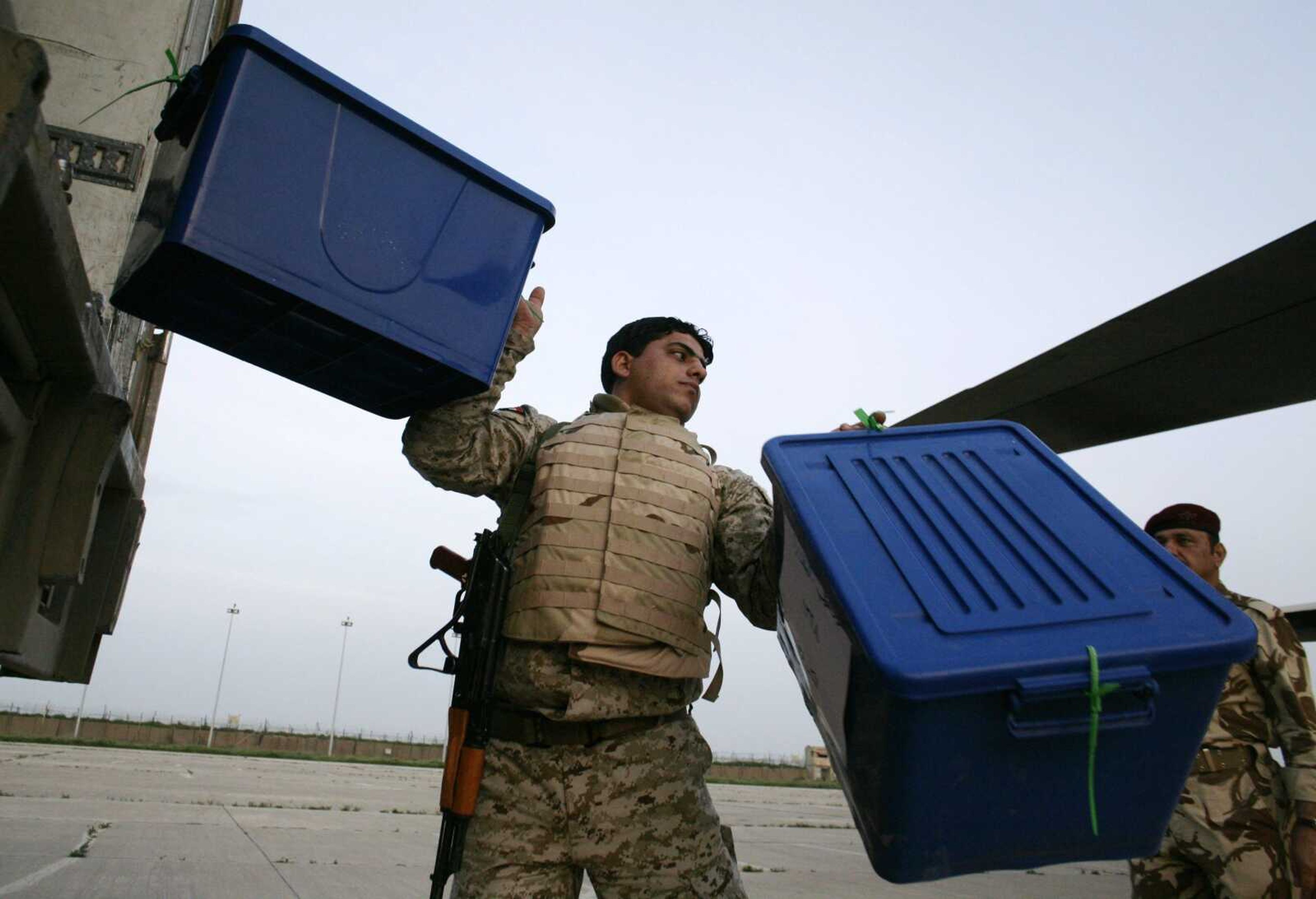 An Iraqi soldier carries a box of ballot tally sheets from Nineveh province for the national election to an Iraqi military cargo plane bound for Baghdad, in Mosul, Iraq, on Monday. (MAYA ALLERUZZO ~ Associated Press)