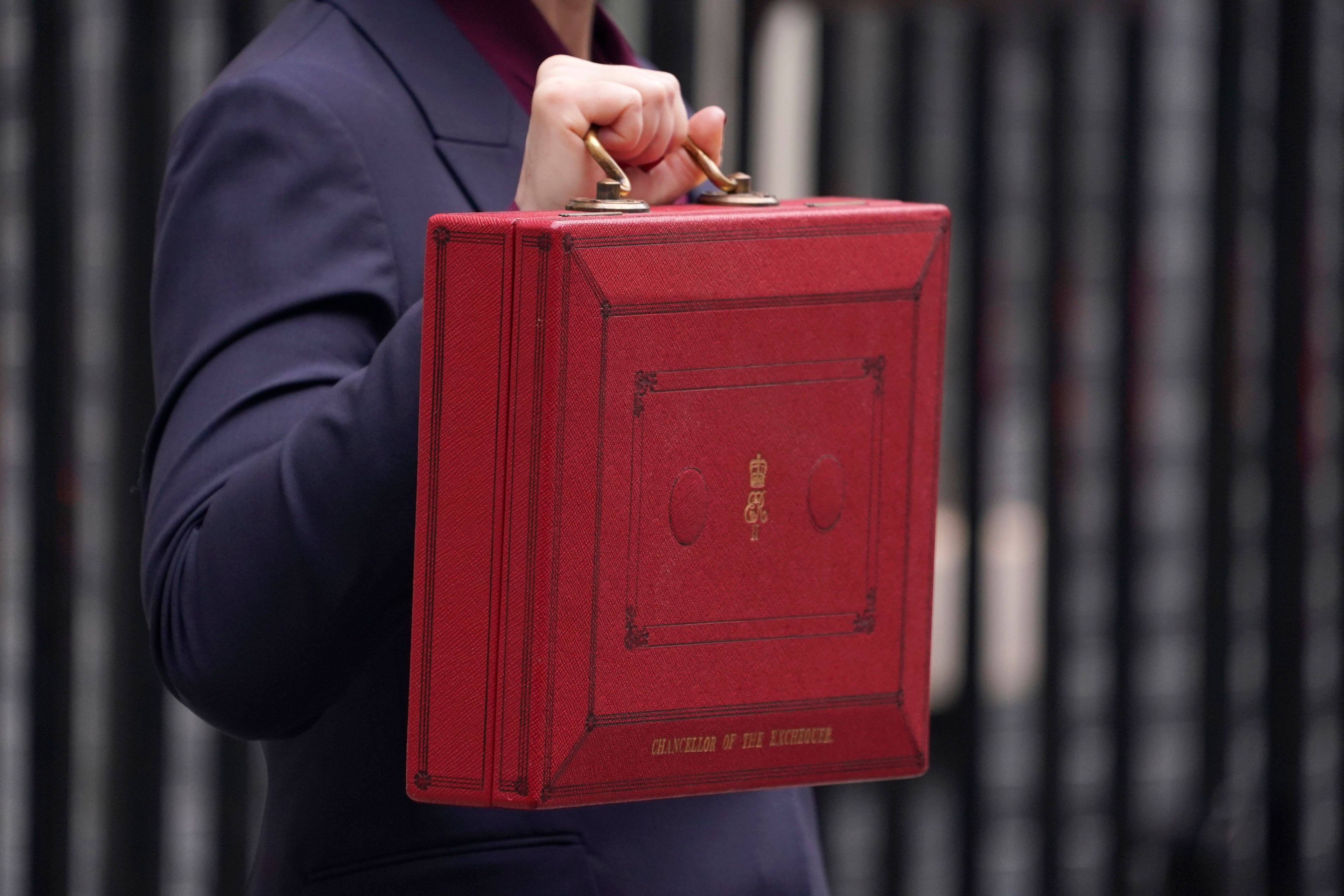 Britain's Chancellor of the Exchequer, Rachel Reeves, holds up the traditional red ministerial box containing her budget speech, as she poses for the media outside No 11 Downing Street, before departing to the House of Commons to deliver the budget in London, Wednesday, Oct. 30, 2024. (AP Photo/Alberto Pezzali)