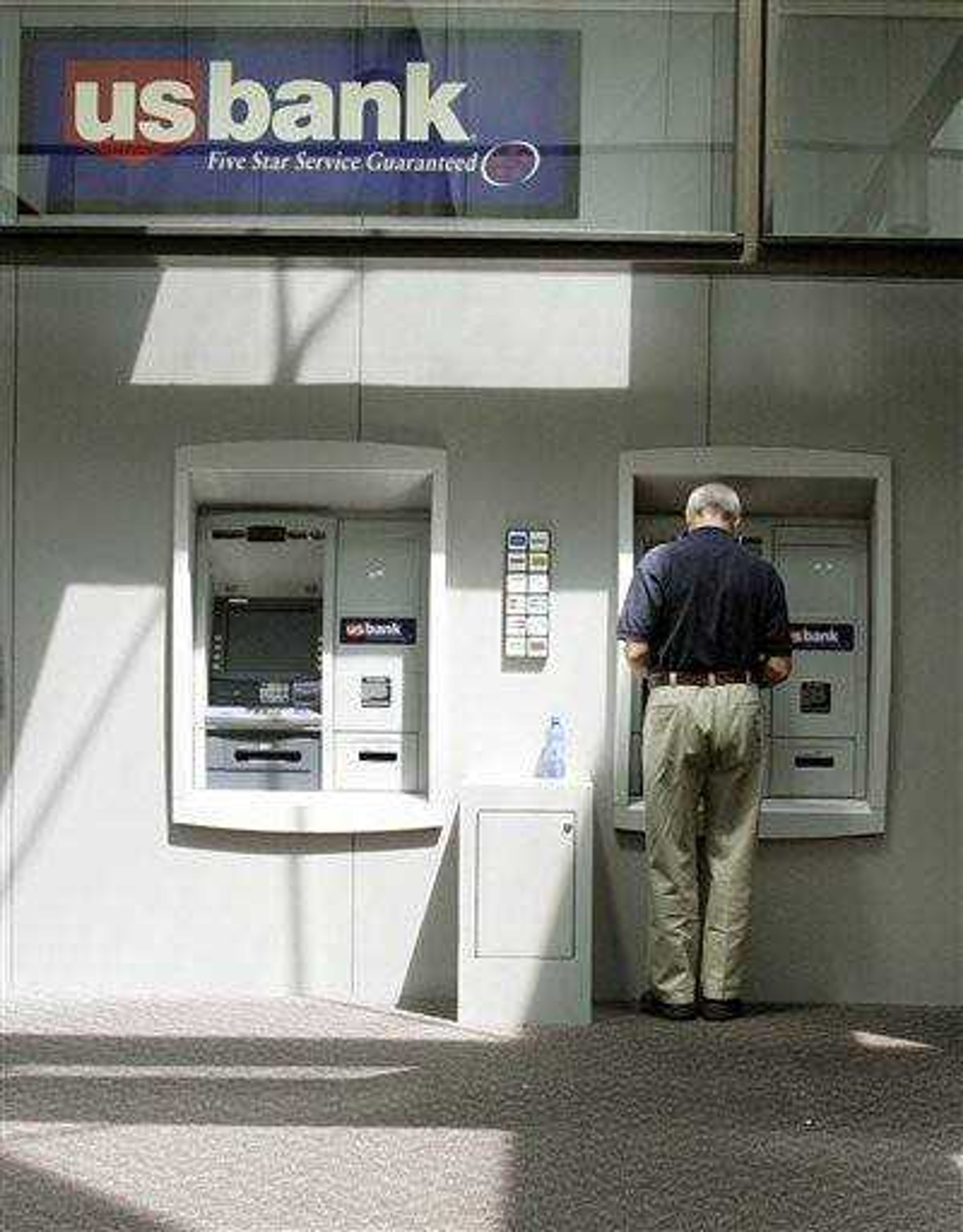 FILE - In this July 18, 2006 file photo, a customer uses a U.S. Bank ATM in a Minneapolis. The Treasury Department said  June 9 it will allow 10 of the nation's largest banks to repay $68 billion in government bailout money.  (AP Photo/Ann Heisenfelt, File)