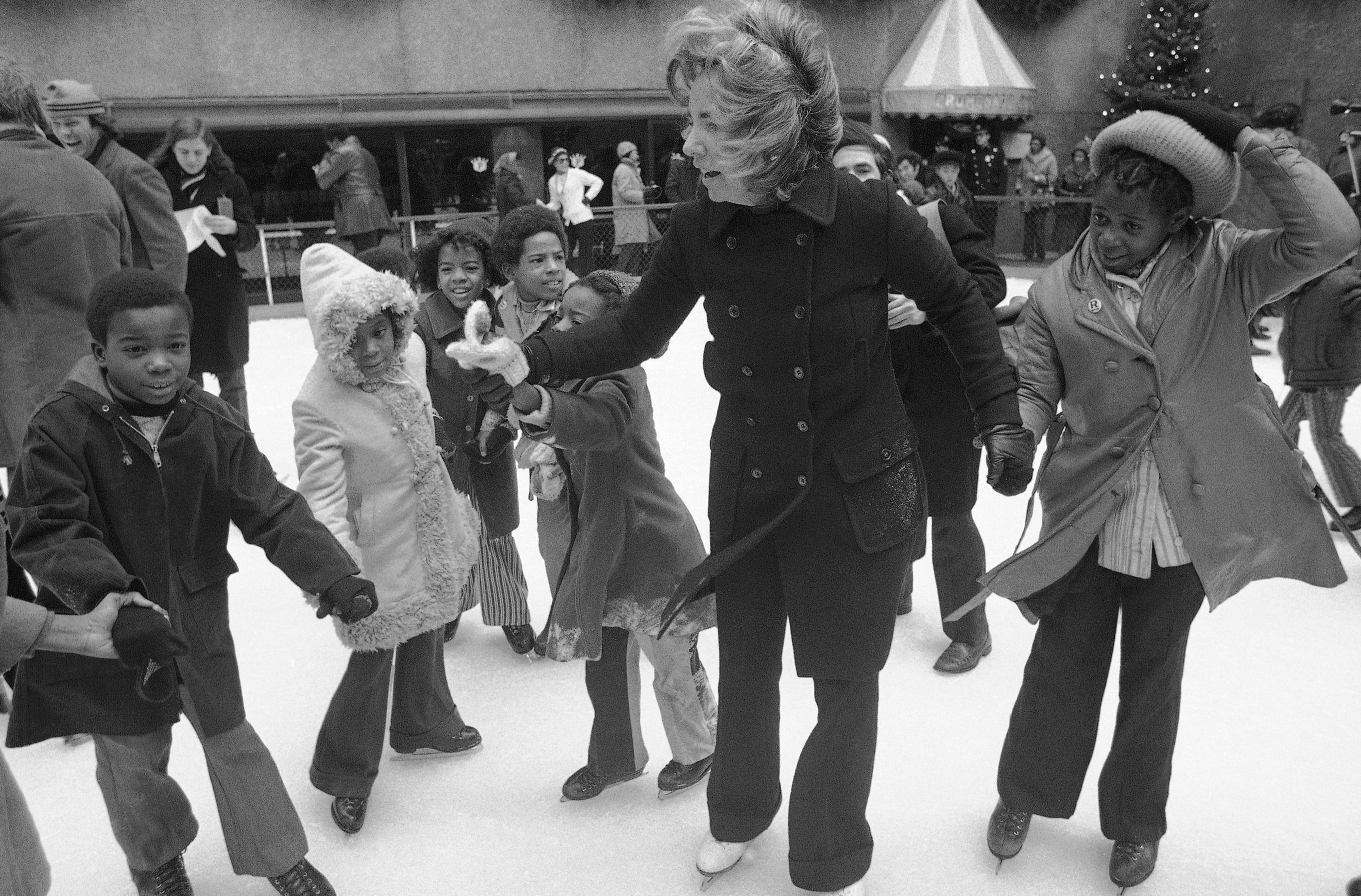 FILE - Ethel Kennedy, widow of Sen. Robert Kennedy, ice skates with youngsters from Bedford Stuyvesant, Brooklyn borough, at the eighth annual Kennedy skating party originated by the late senator at Rockefeller Center's skating rink on Dec. 16, 1972, in New York. (AP Photo/Jim Wells, File)