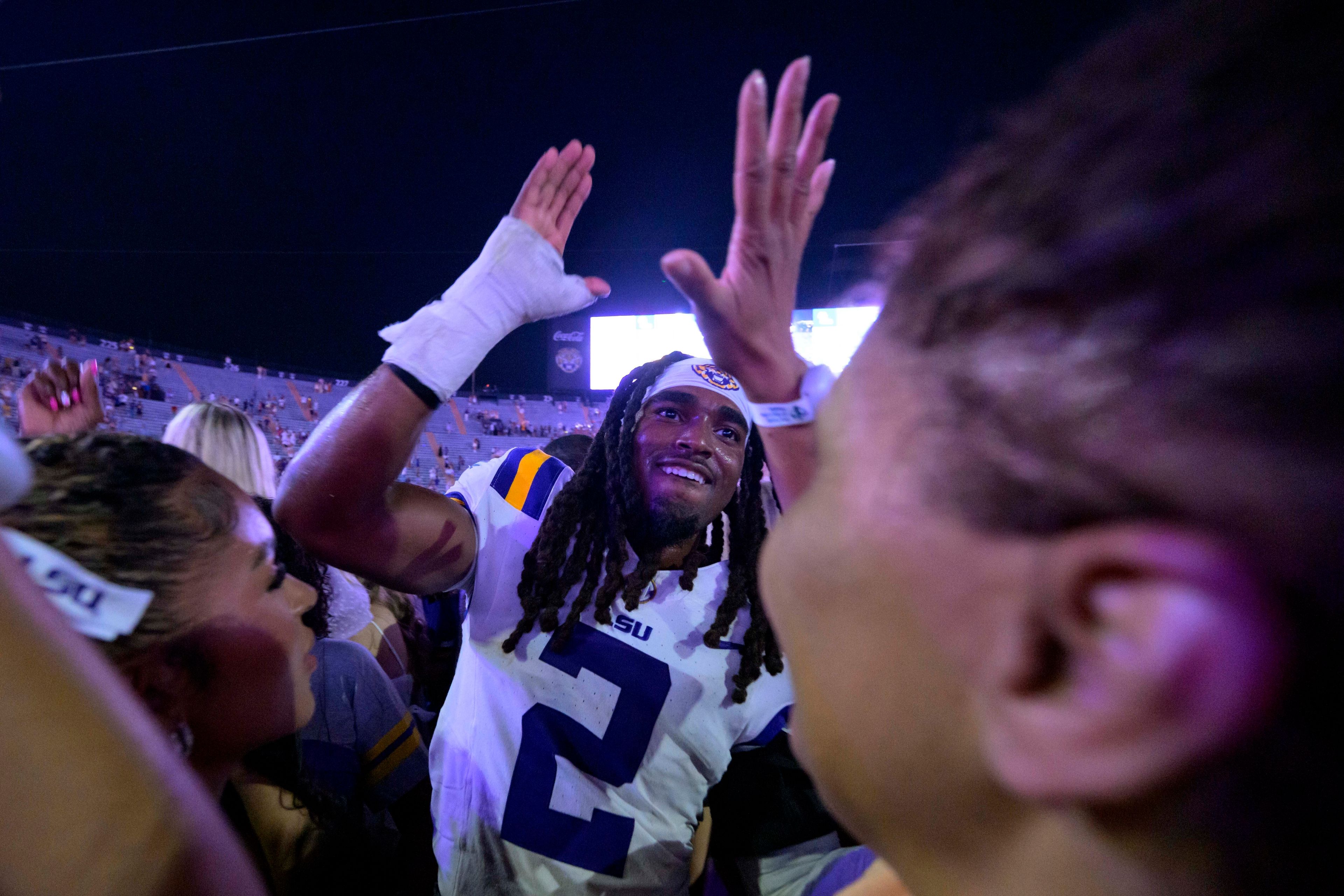 FILE - LSU safety Jardin Gilbert (2) celebrates with fans after they rushed the field after the team's overtime victory against Mississippi in an NCAA college football game in Baton Rouge, La., Saturday, Oct. 12, 2024. (AP Photo/Matthew Hinton, File)