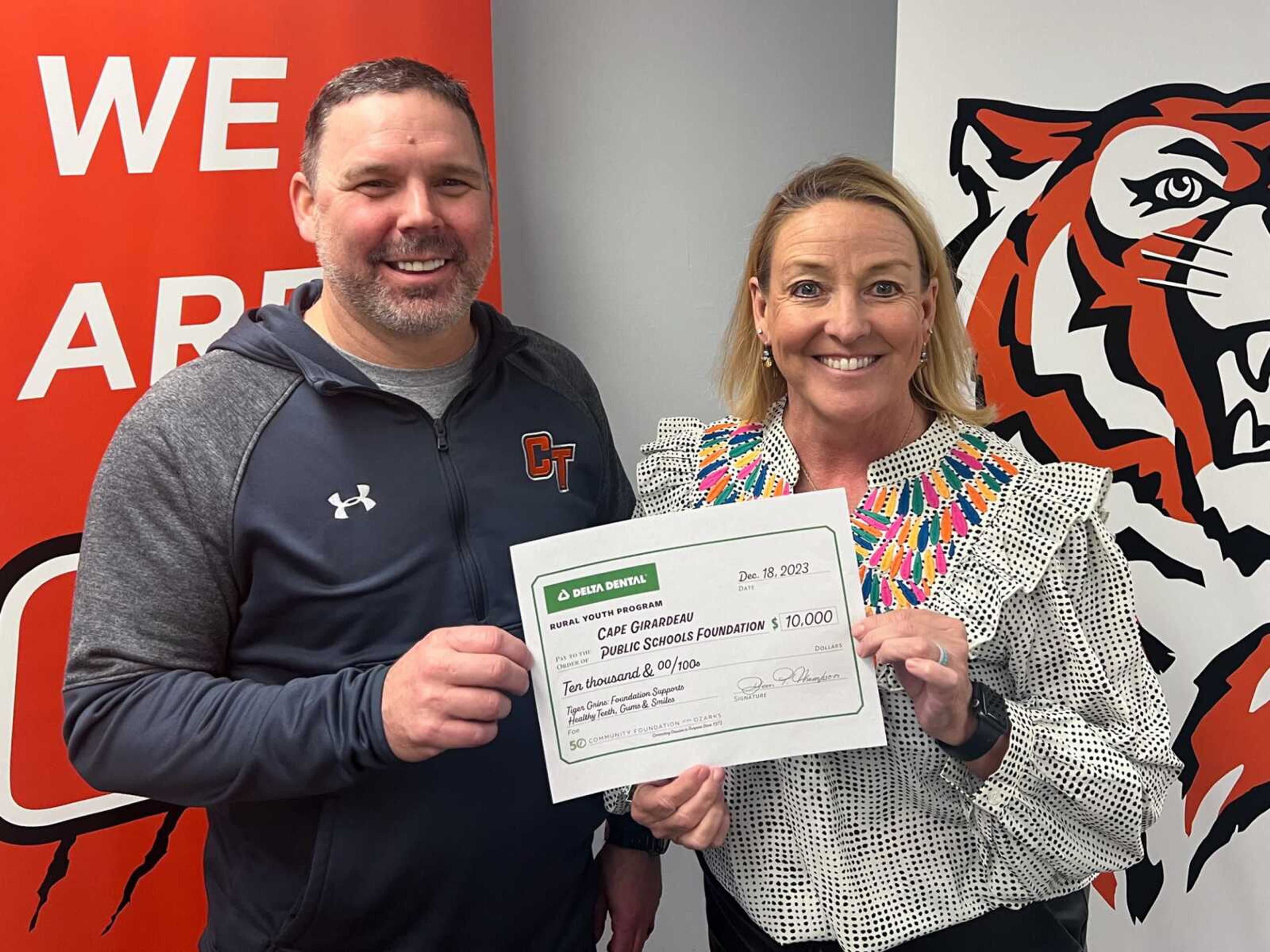 Howard Benyon, left, Cape Girardeau Public Schools superintendent, and Amy McDonald, executive director with the Cape Girardeau Public Schools Foundation, hold a check received from Community Foundation of the Ozarks and Delta Dental of Missouri.