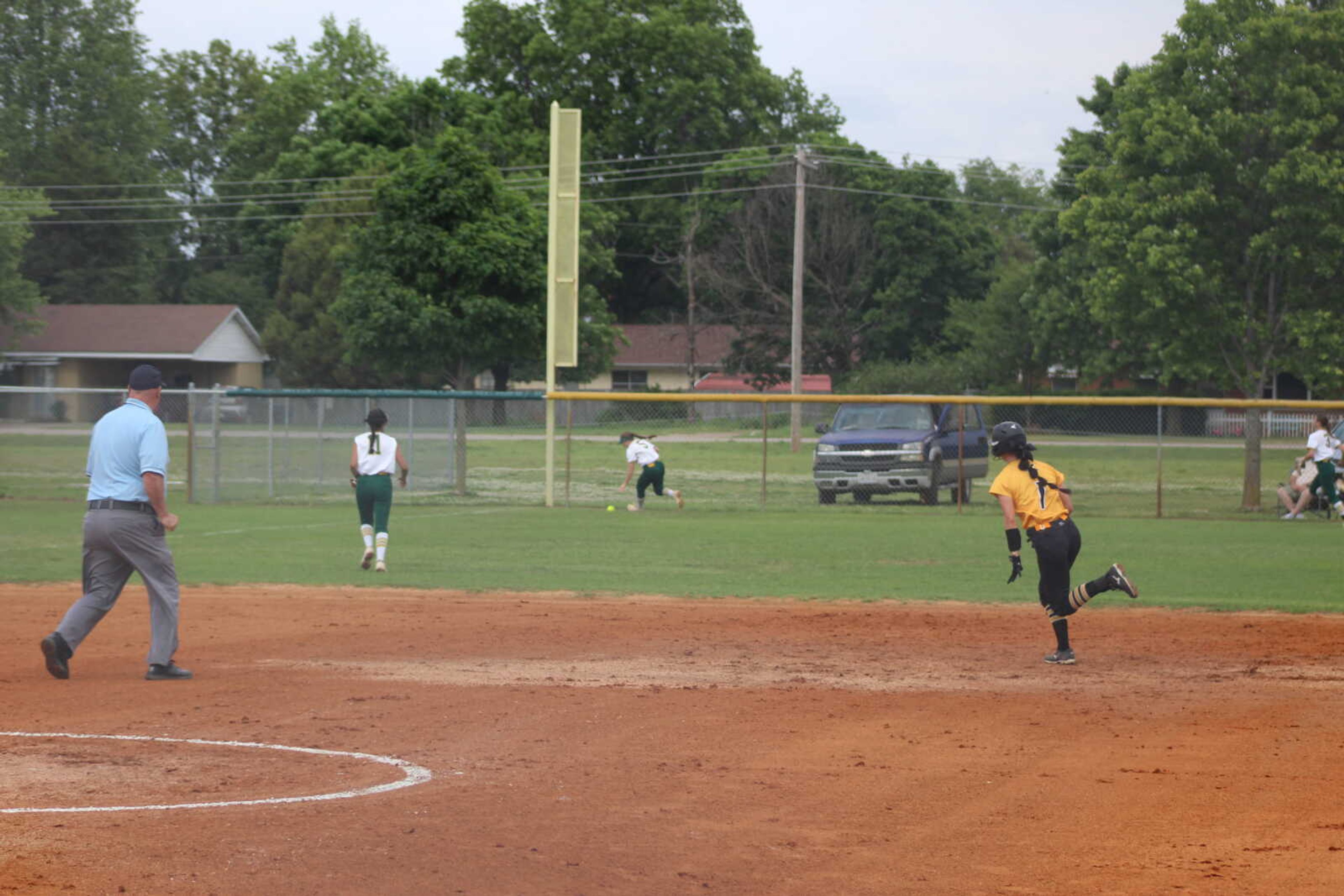 Kennett Lady Indian Handley McAtee heads for third while Malden outfielders jump on Hadley Wilson's hit as it comes off the left field fence Monday at Malden.