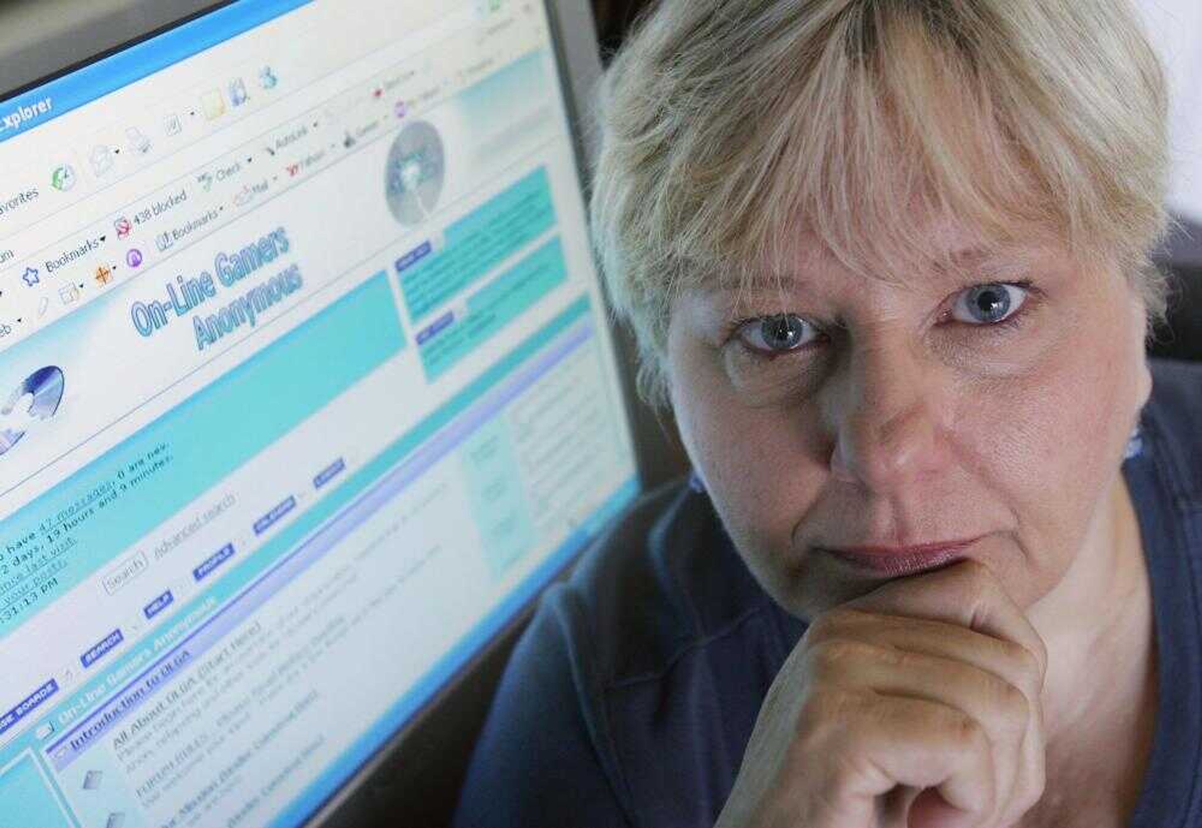 Joyce Protopapas posed Wednesday at her home in Frisco, Texas, by a computer with the Web site of the support group On-Line Gamers Anonymous on the screen. Protopapas says video and Internet games transformed her son, Michael, from a courteous, outgoing, academically gifted teen into an aggressive, reclusive manipulator who flunked two 10th-grade classes and spent several hours day and night playing a popular online video game. (Donna McWilliam ~ Associated Press)