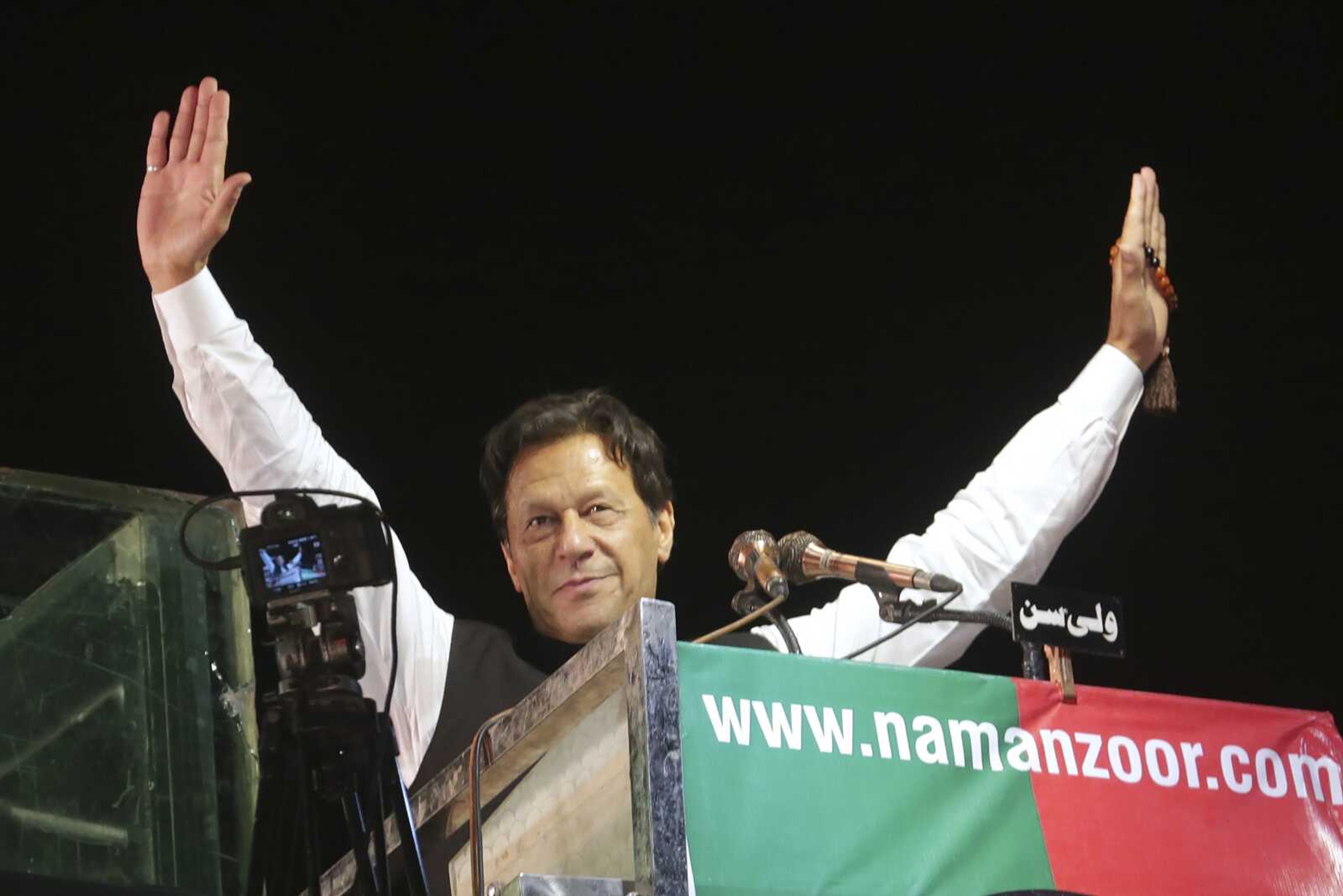 Former Pakistani Prime Minister Imran Khan waves to his supporters during an anti-government rally April 21 in Lahore, Pakistan. Pakistani police have filed terrorism charges against Khan, authorities said Monday, escalating political tensions in the country as he holds mass rallies seeking to return to office.