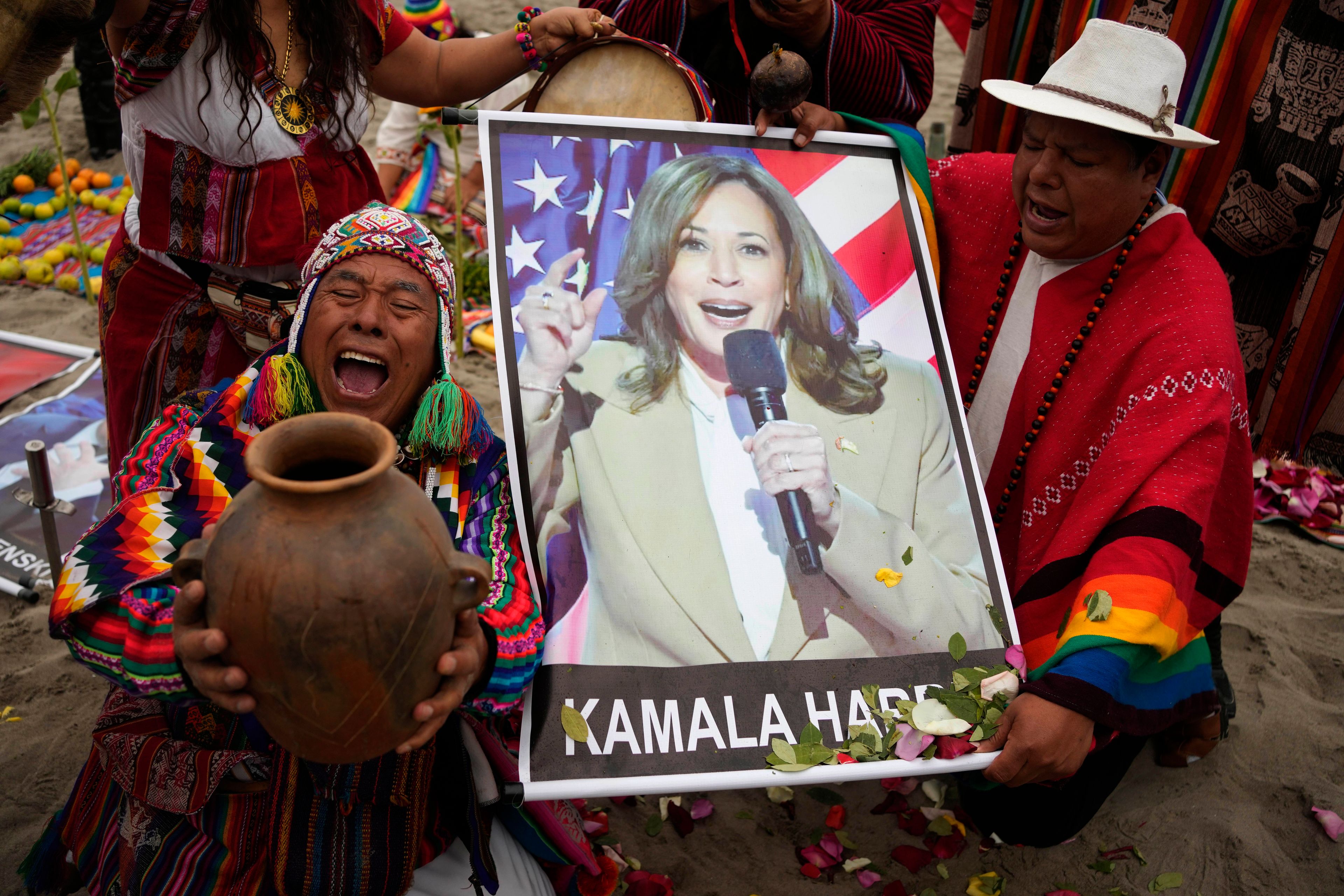 Shamans perform a good luck ritual holding photo a poster of Democratic presidential nominee Vice President Kamala Harris, at the beach in Lima, Peru, Tuesday, Nov. 5, 2024. (AP Photo/Martin Mejia)