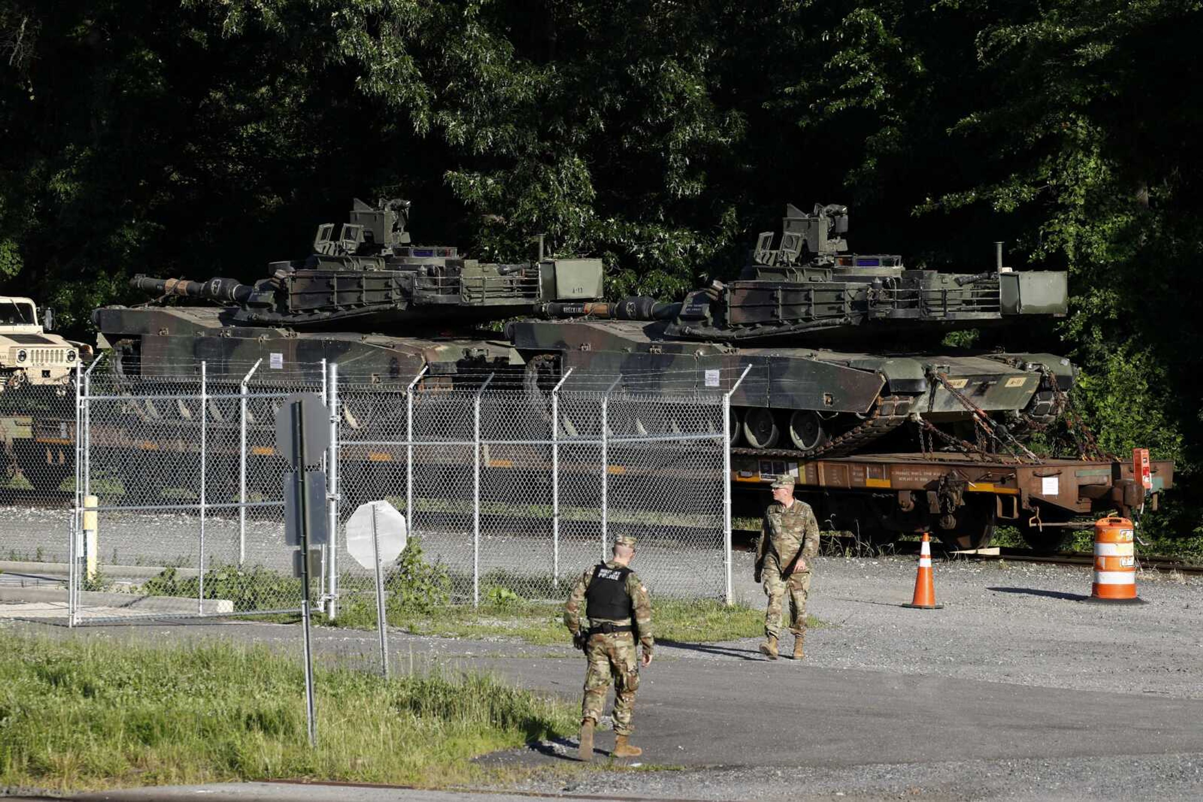 Military police walk near Abrams tanks on a flat car in a rail yard Monday in Washington, ahead of a Fourth of July celebration President Donald Trump said will include military hardware.