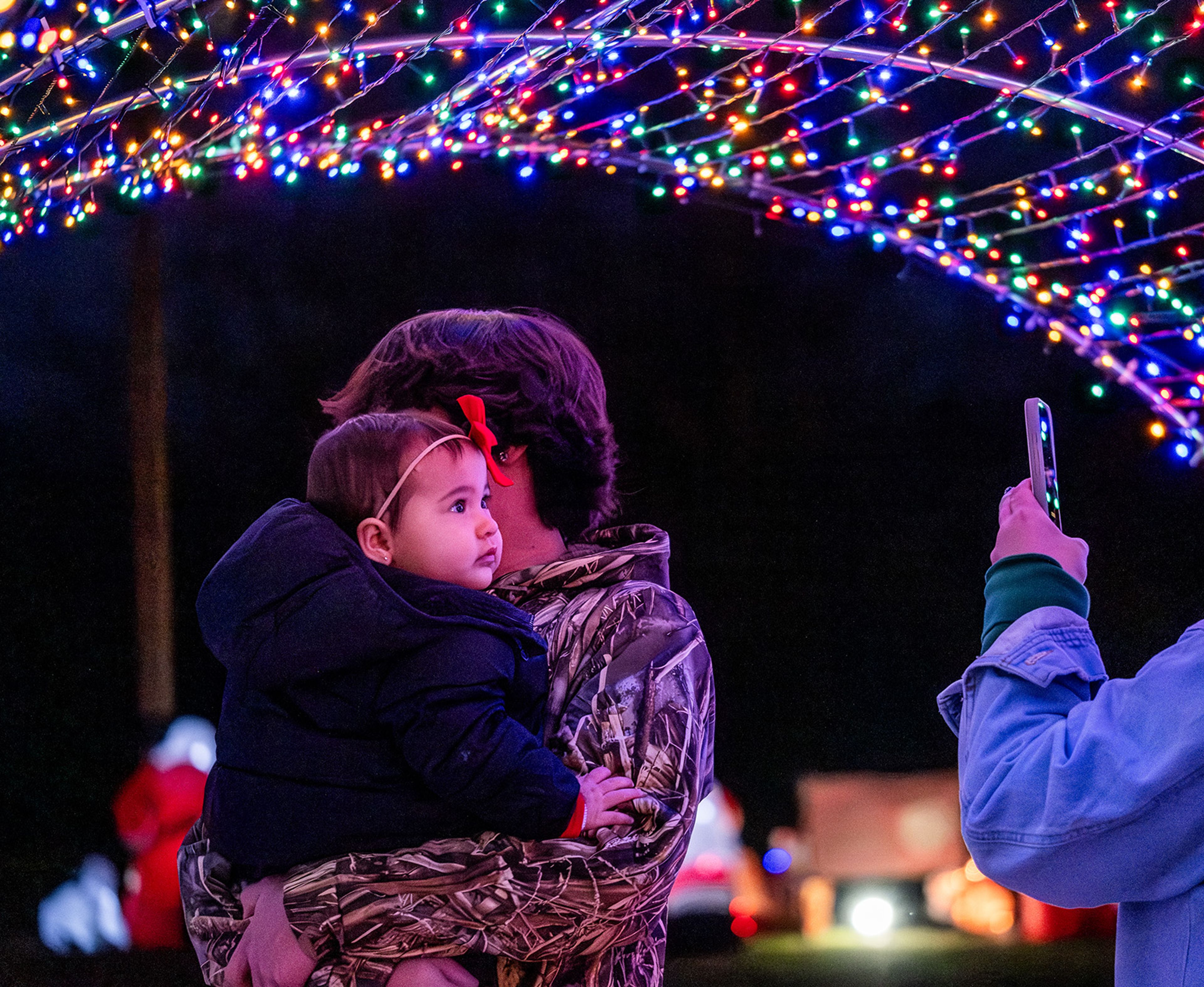 Families pose for photos under a beautifully lit archway.