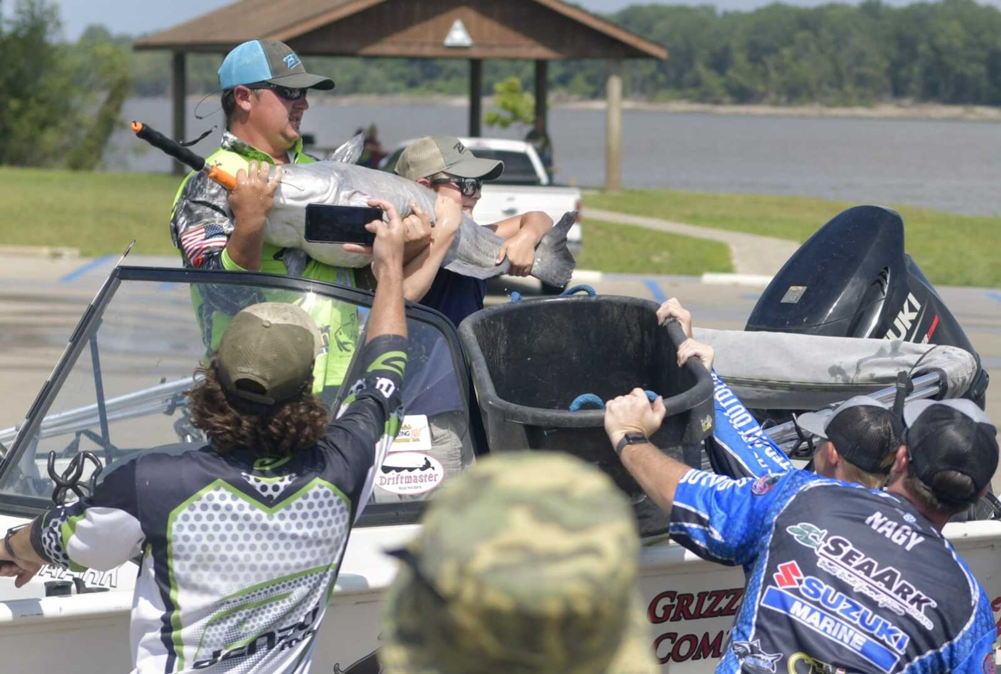 Hunter Jones, above left, and his 10-year-old son, Ryder, raise a 48.28-pound catfish before weighing in with a total weight of 74.36 pounds at the Red Star Access on Saturday during the Twisted Cat Outdoors summer series tournament stop in Cape Girardeau.