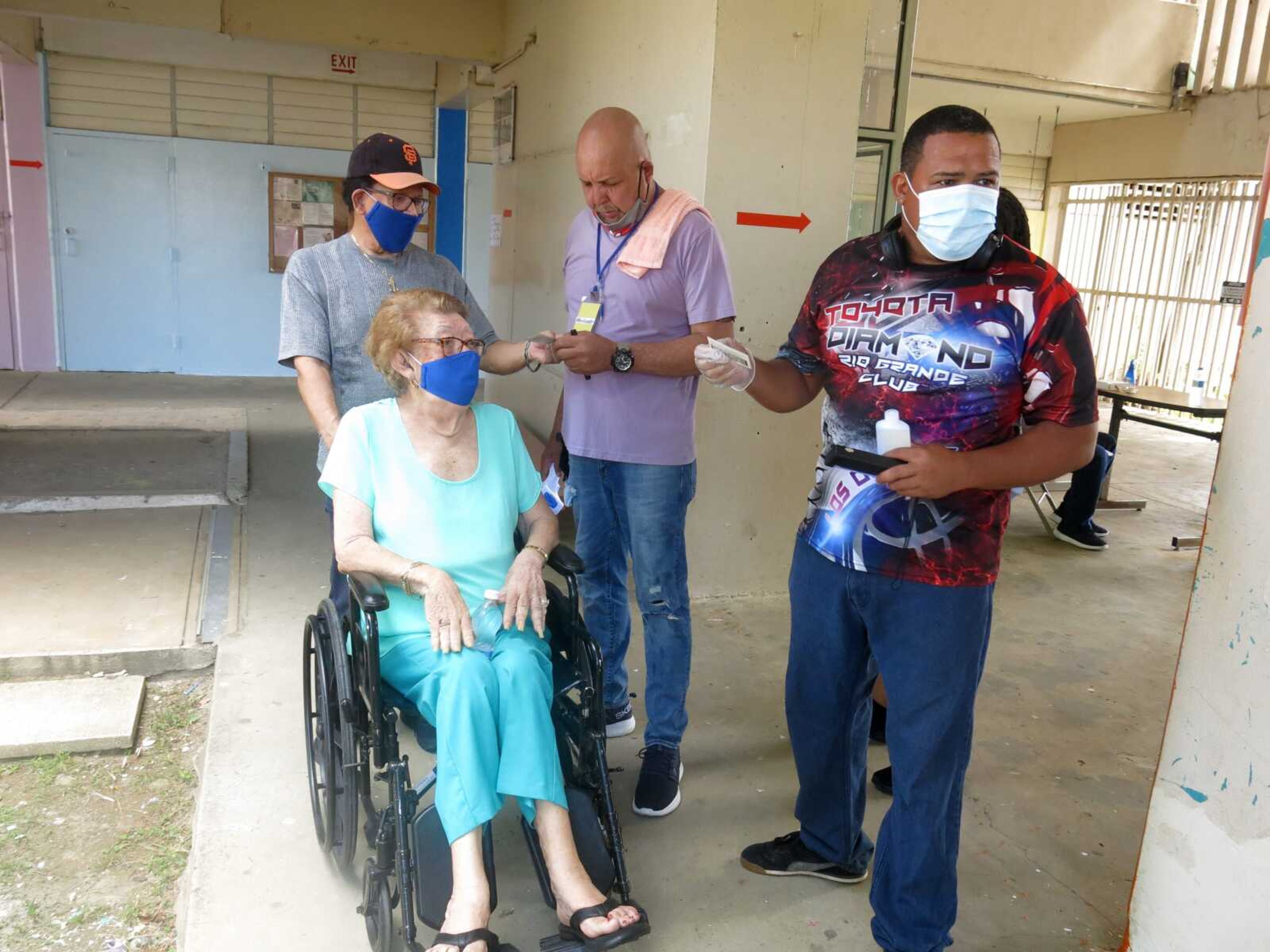 A volunteer assists voters Sunday in Loiza, Puerto Rico.ÃŸ