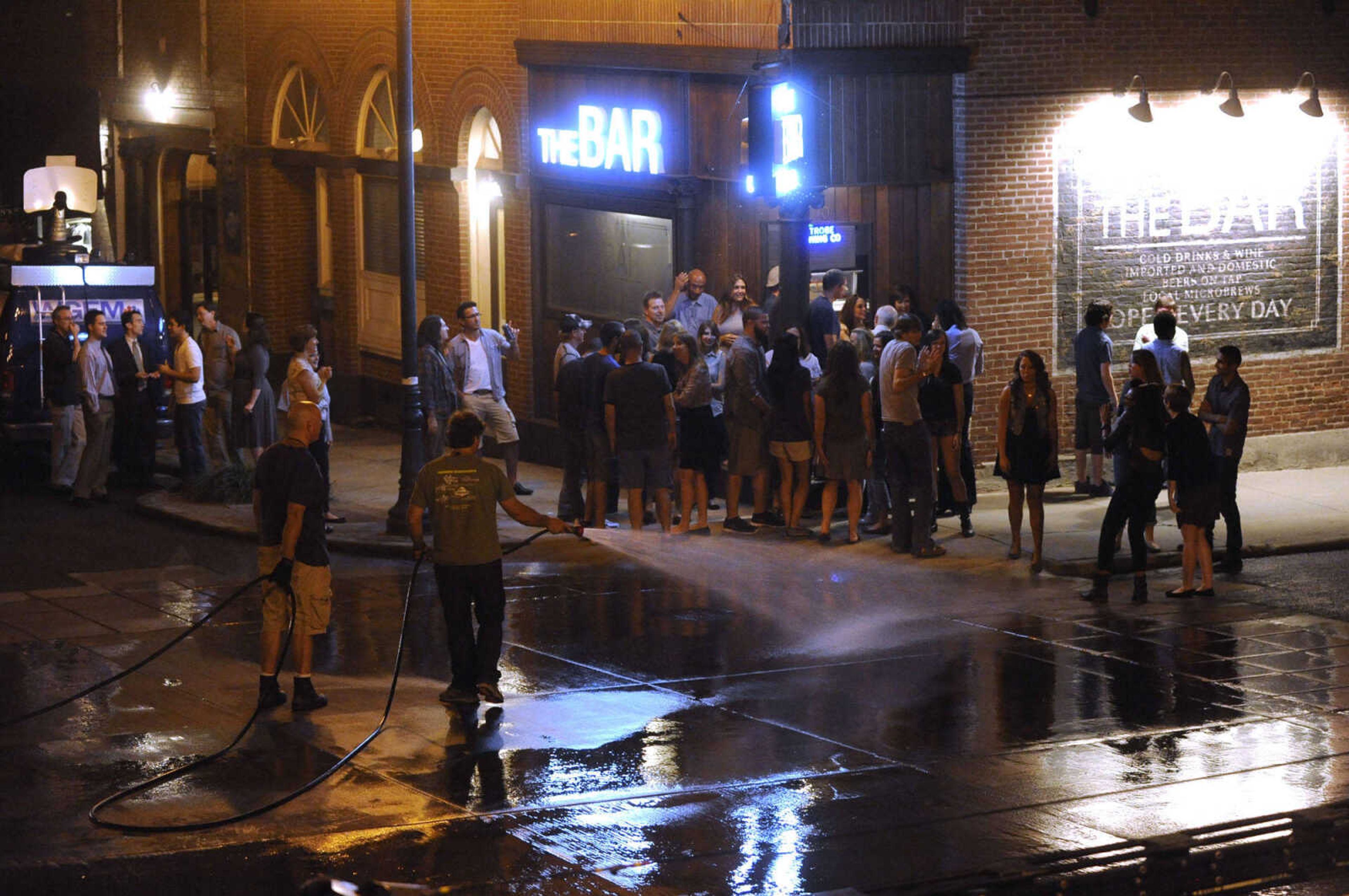 FRED LYNCH ~ flynch@semissourian.com
A "Gone Girl" crew member sprays water onto the street outside The Bar Friday, Sept. 27, 2013 in downtown Cape Girardeau.