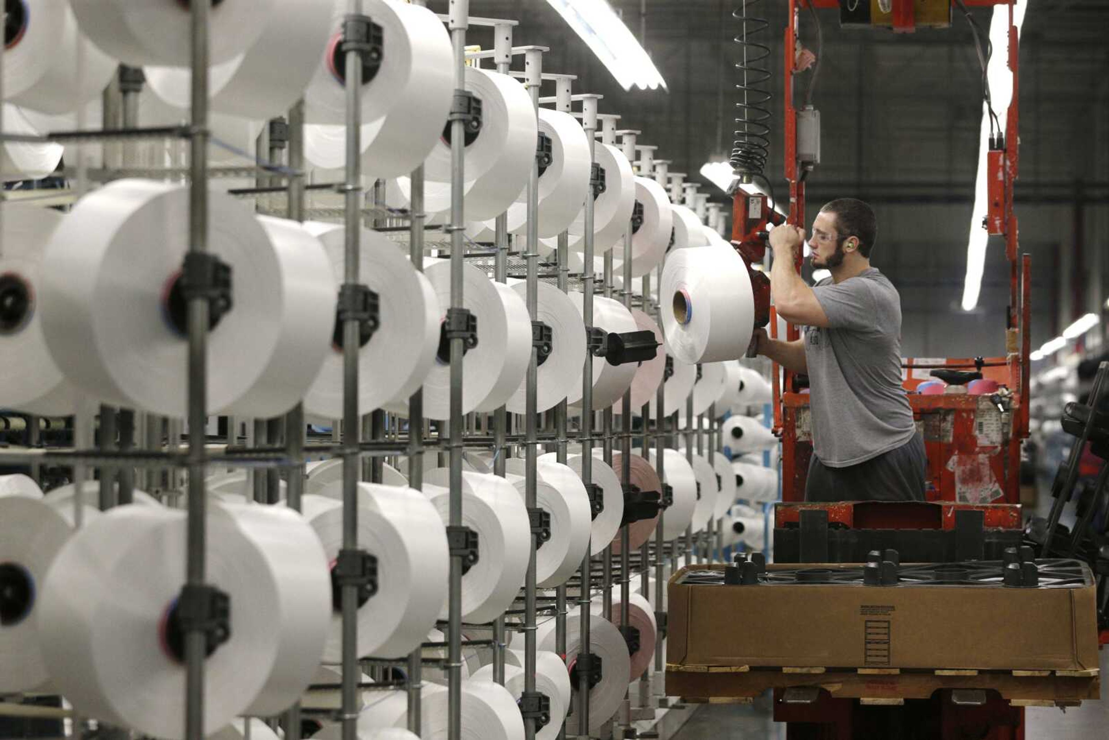 A worker loads spools of thread at the Repreve Bottle Processing Center, part of the Unifi textile company in Yadkinville, North Carolina.