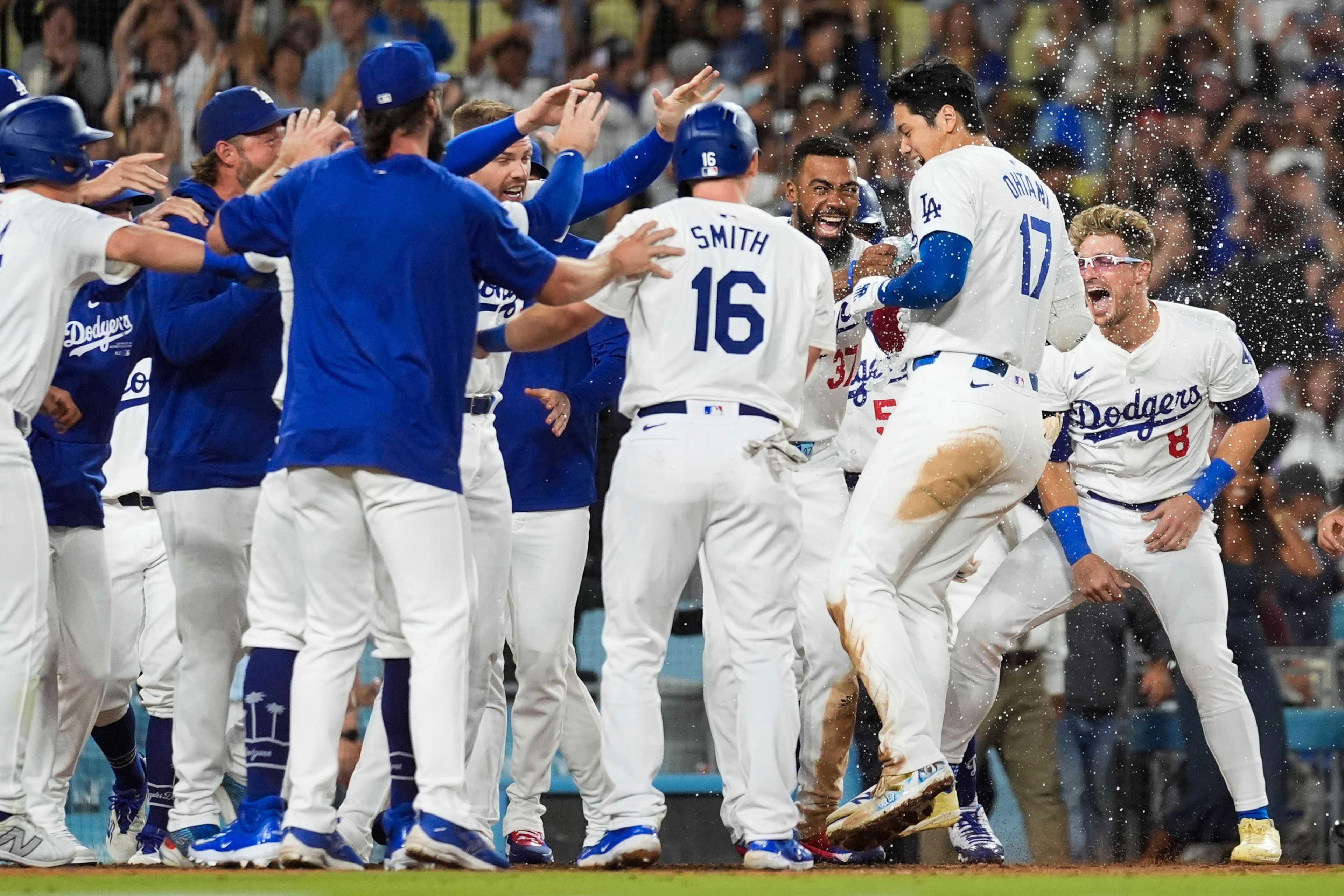 Los Angeles Dodgers designated hitter Shohei Ohtani (17) celebrates with teammates after hitting a grand slam during the ninth inning of a baseball game against the Tampa Bay Rays in Los Angeles, Friday, Aug. 23, 2024. The Dodgers won 7-3. (AP Photo/Ashley Landis)