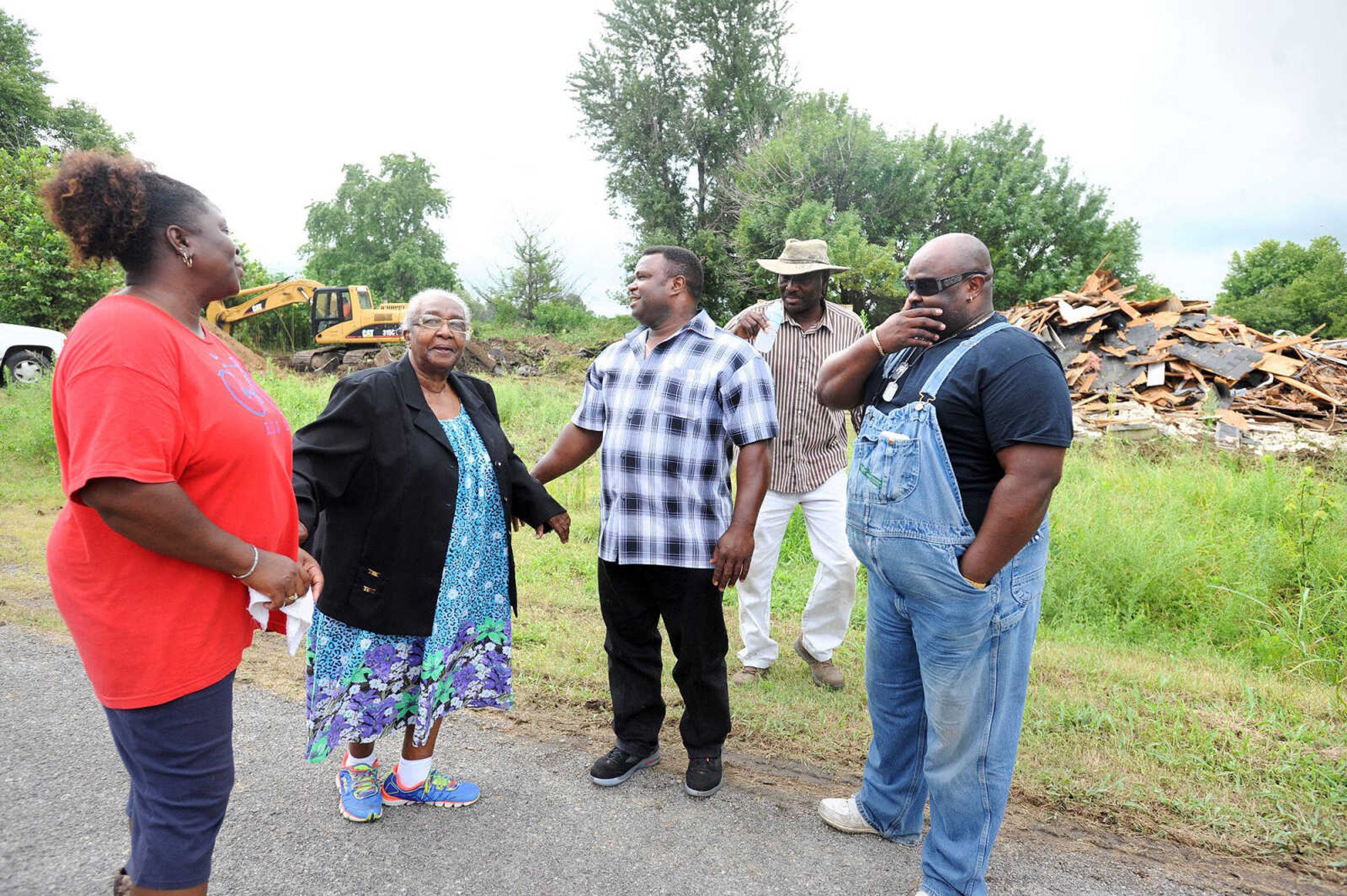 From left, Gloria Merriweather, Aretha Robinson, Reginald Robinson, Leonard Gallion and David Robinson gather together as demolition of the remaining homes in Pinhook begins Thursday. (Laura Simon)