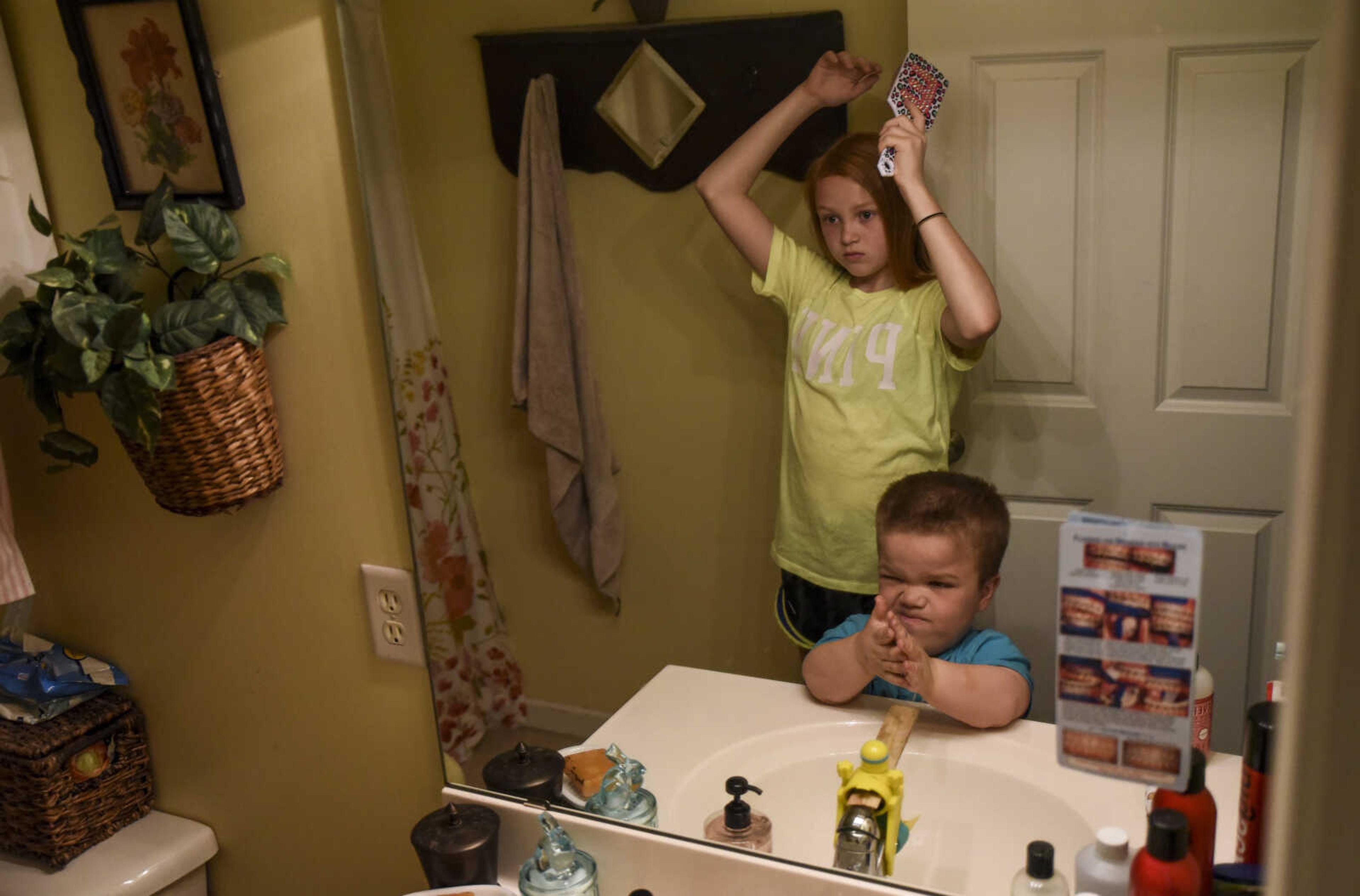 Izaac Pursley gets ready for school with his big sister Evee-Kay Pursley May 3, 2018, in their Jackson home.