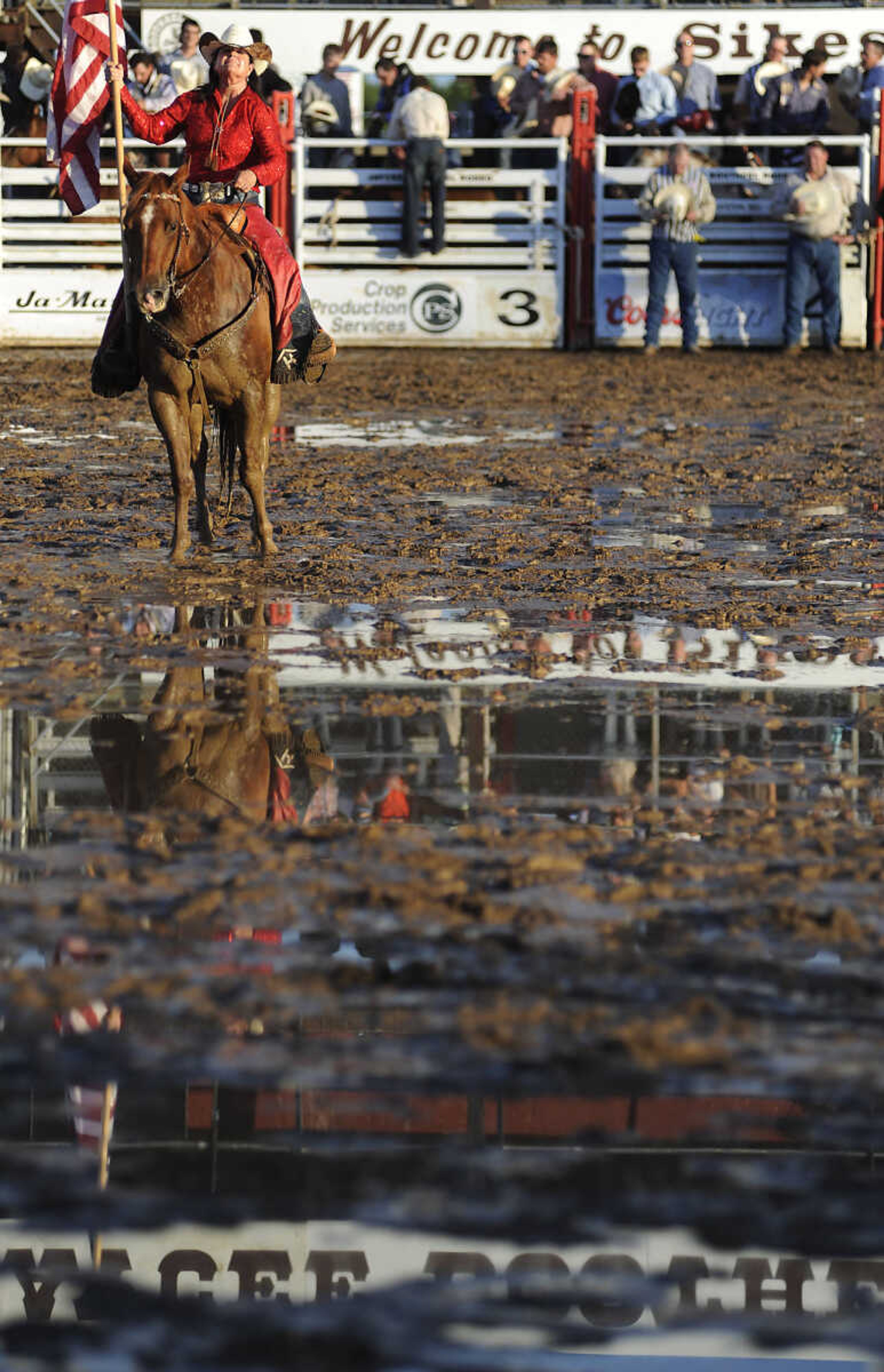 A rider with the American Flag circles the arena as the National Anthem plays before the Sikeston Jaycee Bootheel Rodeo Wednesday, August 7, in Sikeston, Mo.